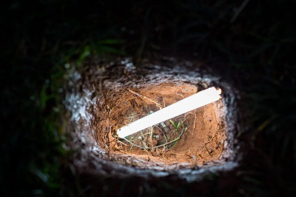 Uma lâmpada está no meio de um buraco no chão.