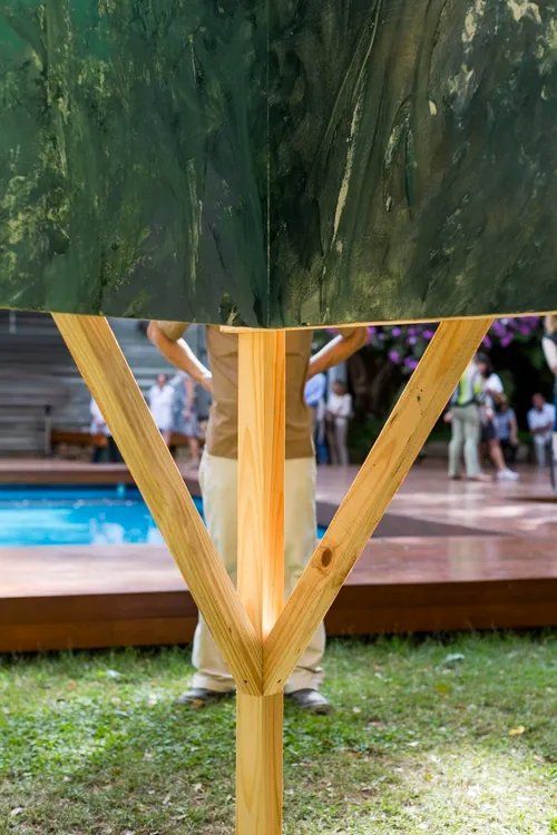 Uma pessoa está sob um guarda-chuva em frente a uma piscina.