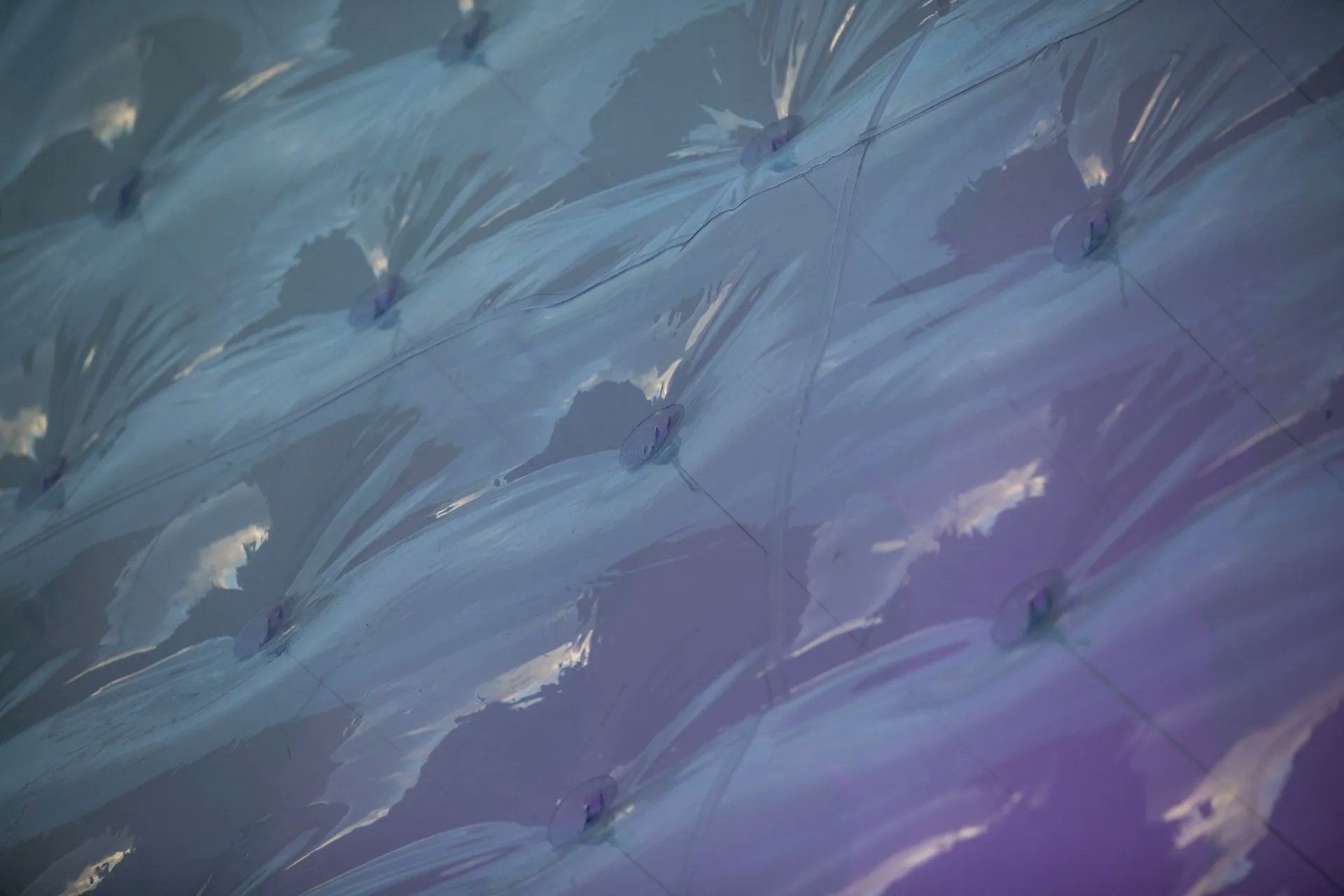 Um close de um sofá azul com fundo roxo.