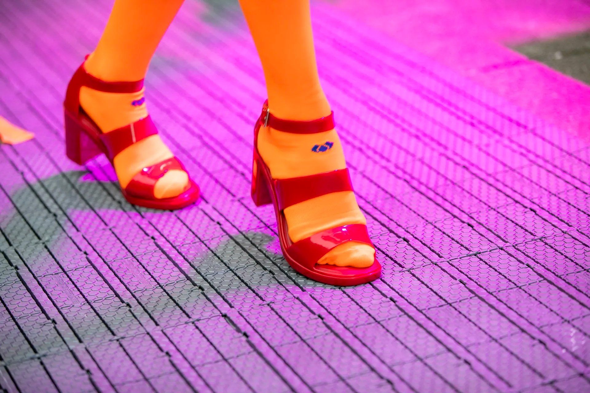 Um close dos pés de uma pessoa usando sandálias vermelhas.