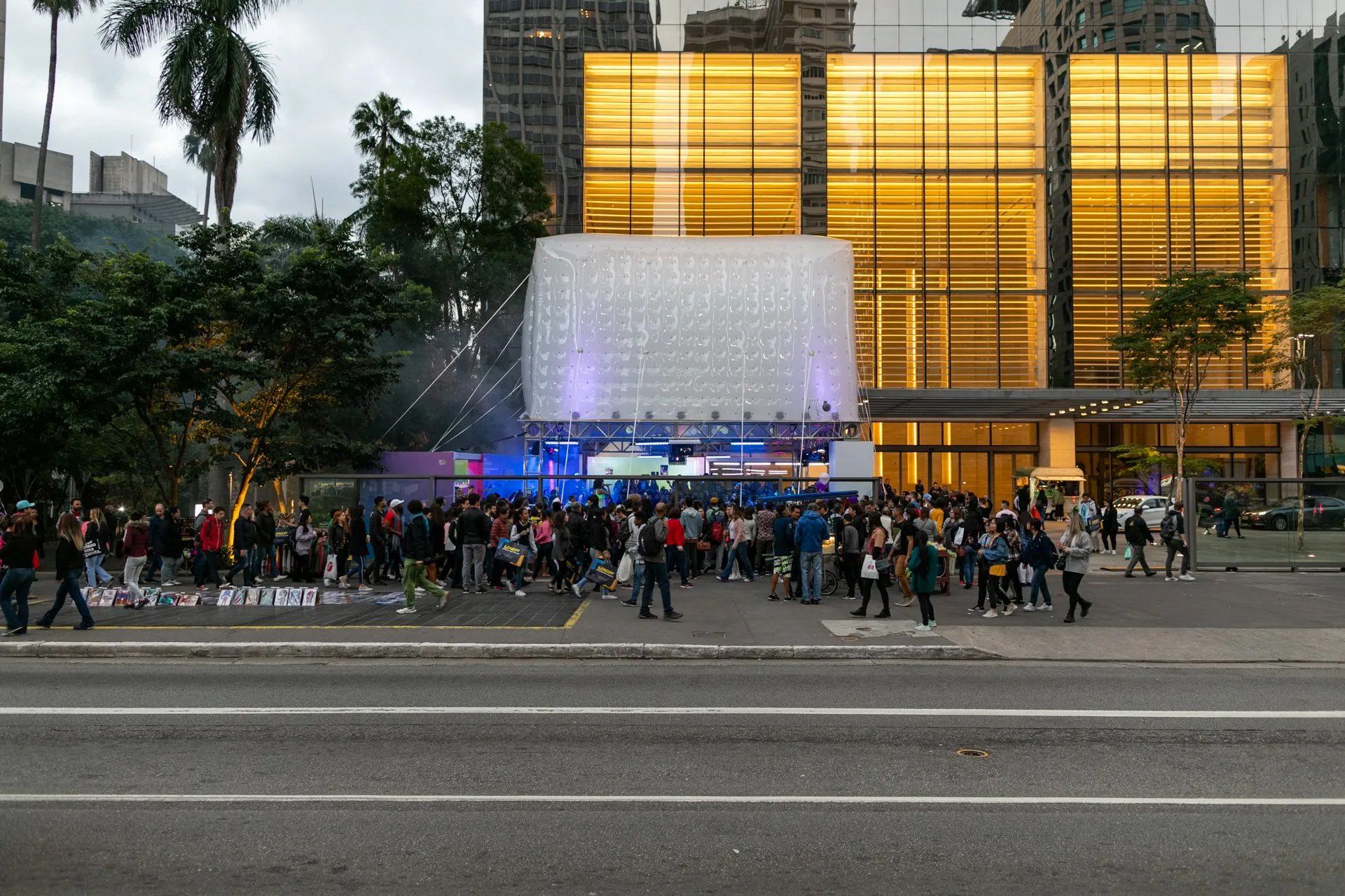 Uma multidão de pessoas está reunida em frente a um grande edifício