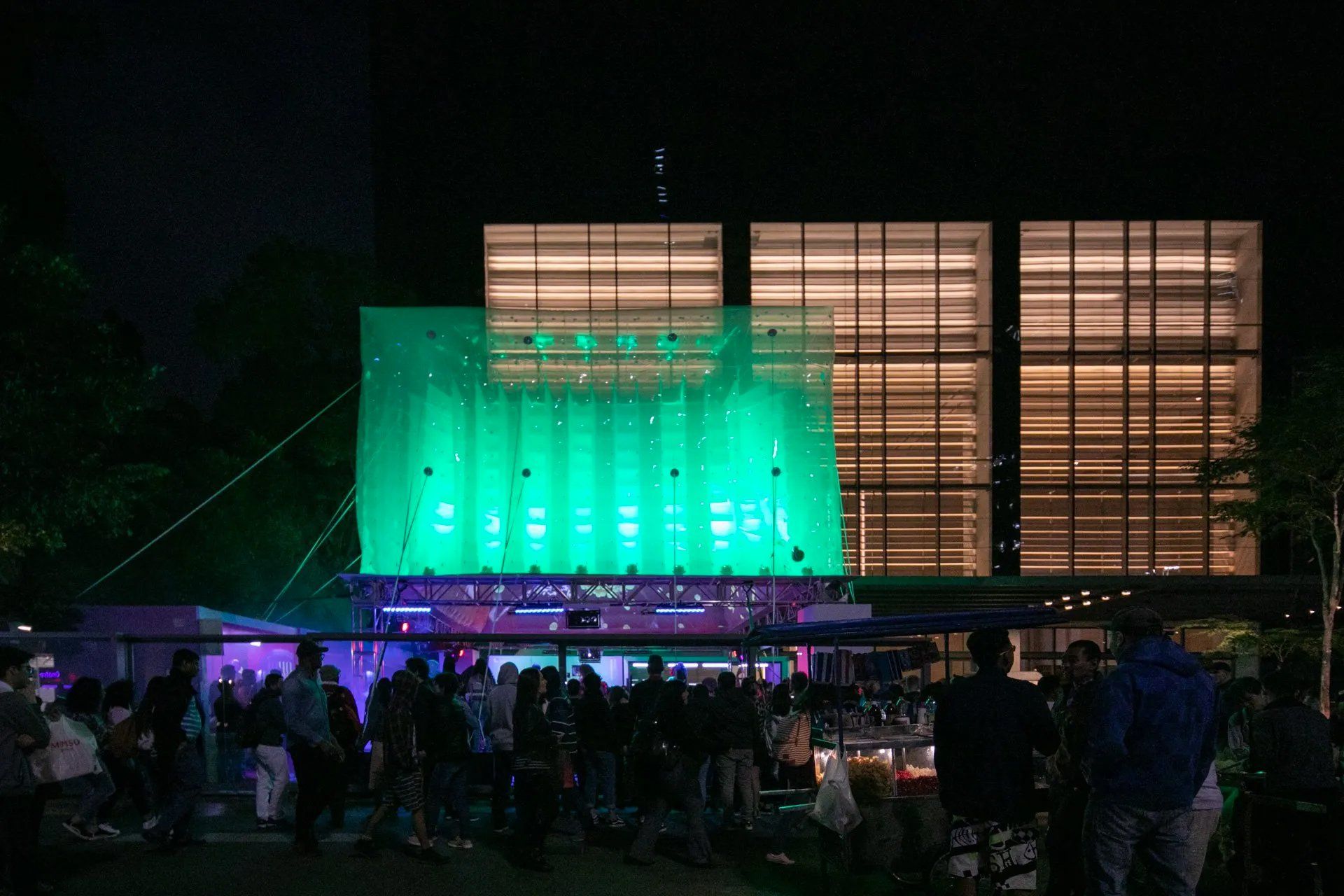 Um grande edifício com muitas janelas é iluminado à noite