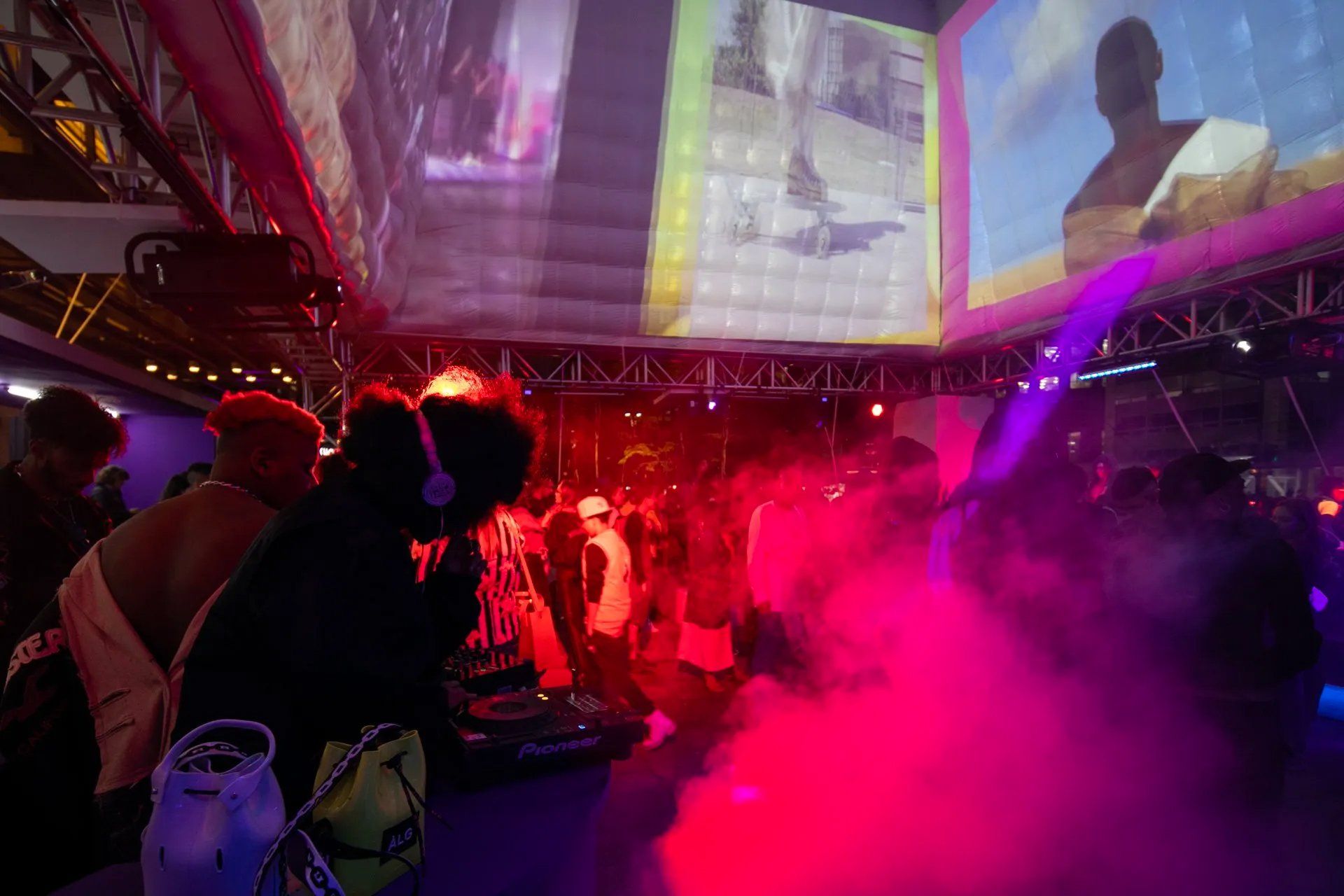 Um grupo de pessoas está em frente a uma grande tela em uma festa.