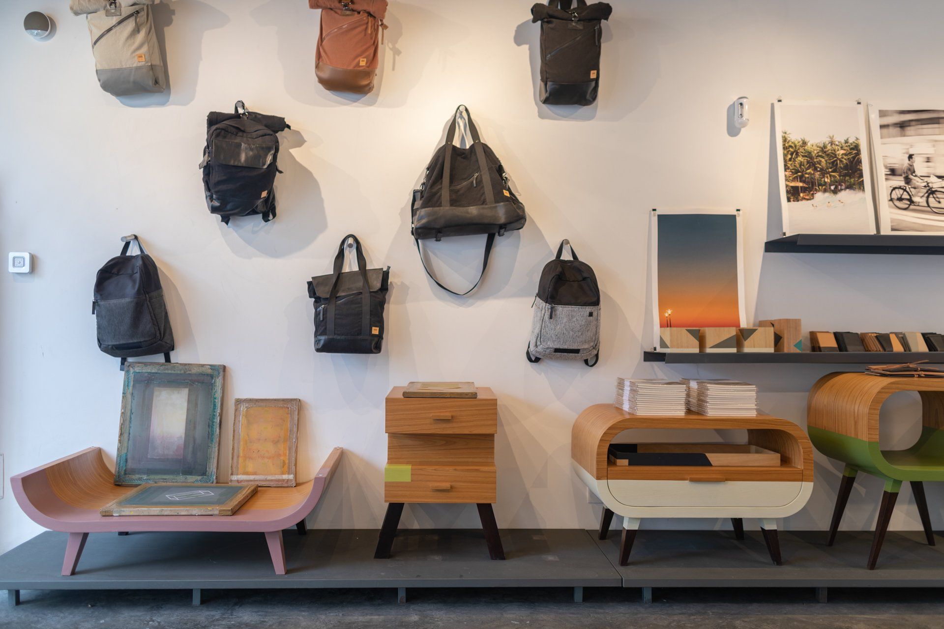 Uma sala com muitos móveis e bolsas penduradas na parede.