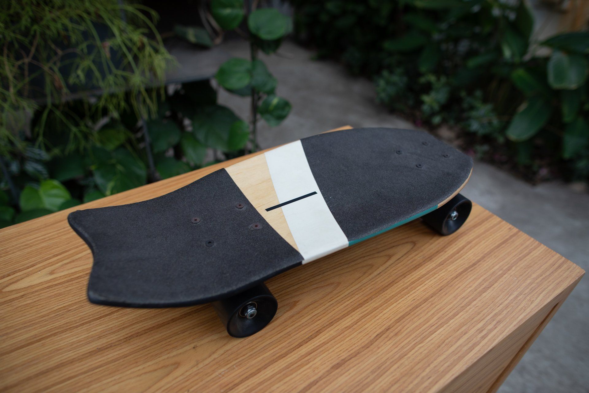 Um skate está em cima de uma mesa de madeira.