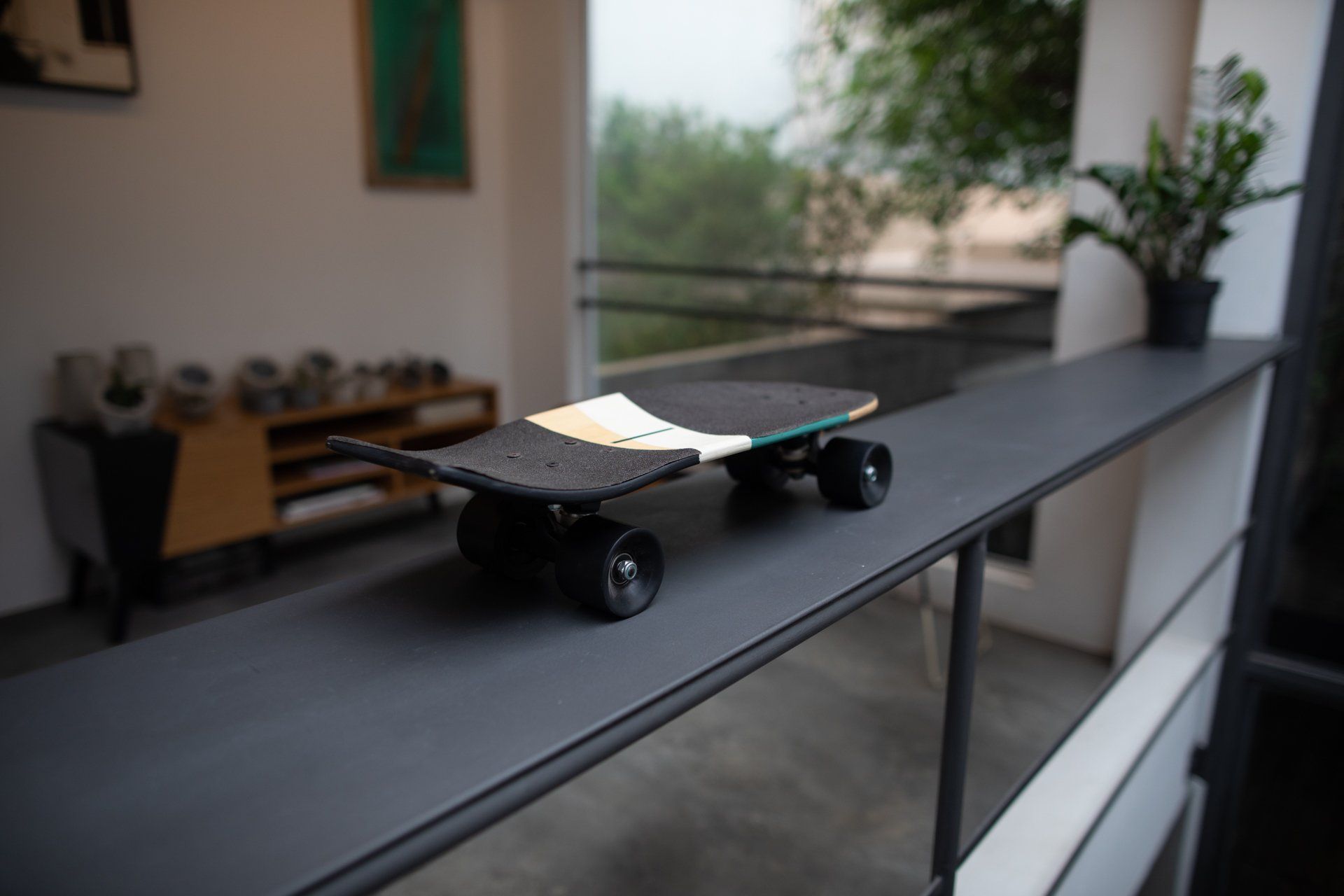 Um skate está apoiado no corrimão de uma sala de estar.