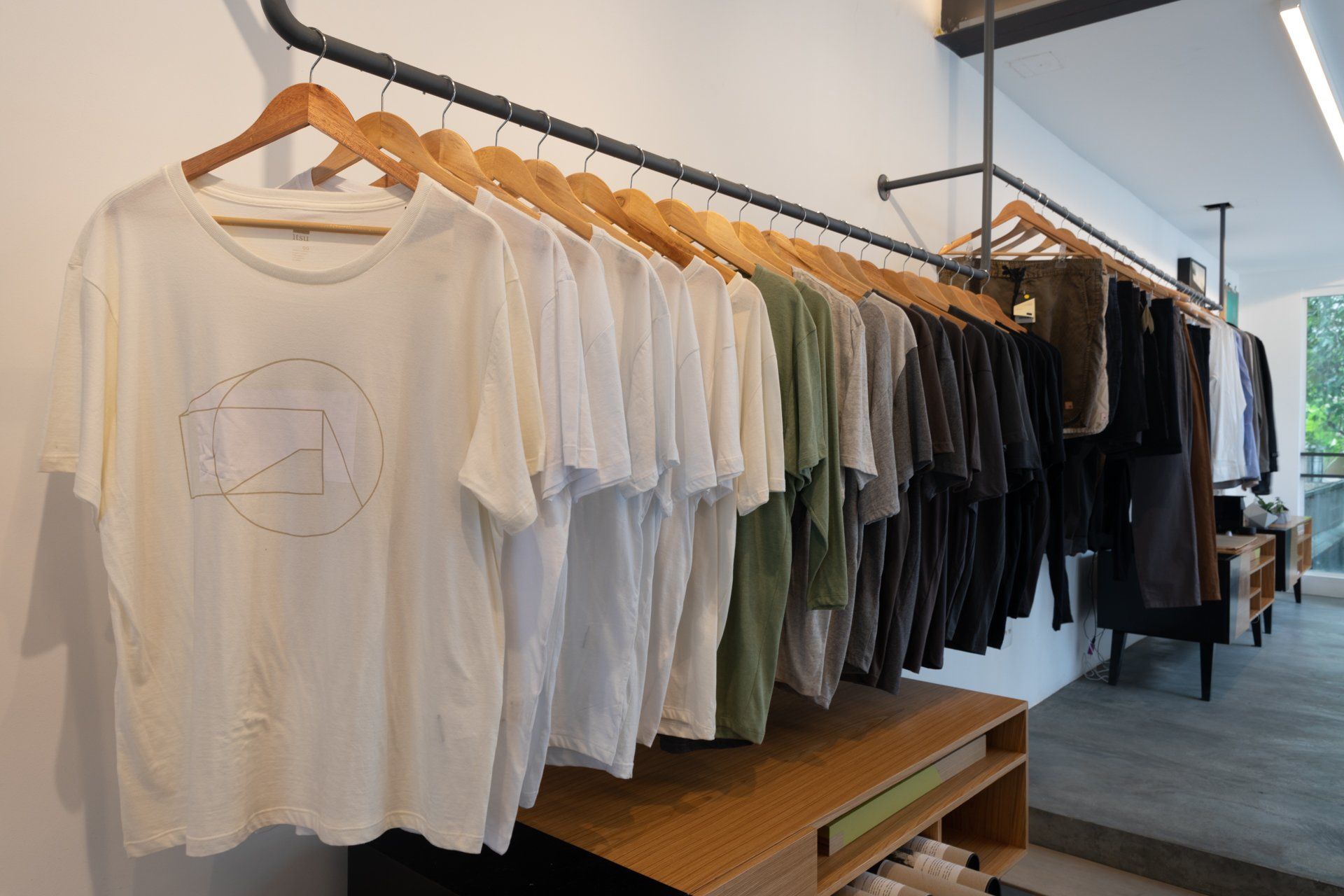 Uma fileira de camisetas penduradas em um rack em uma loja.