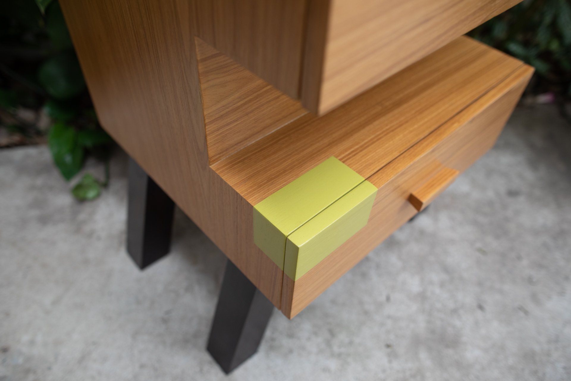 Um close de uma mesa de madeira com uma fita amarela no canto.