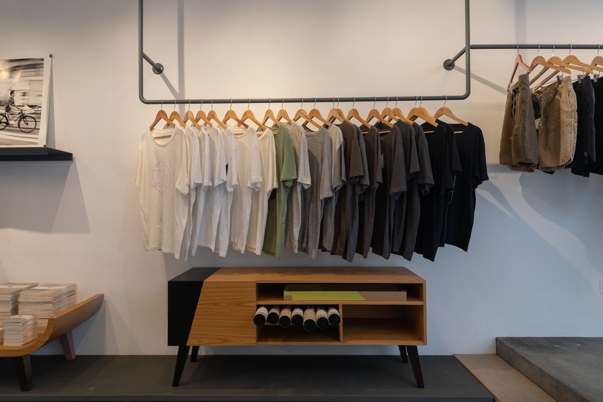 Uma fileira de camisas está pendurada em uma prateleira de uma loja.