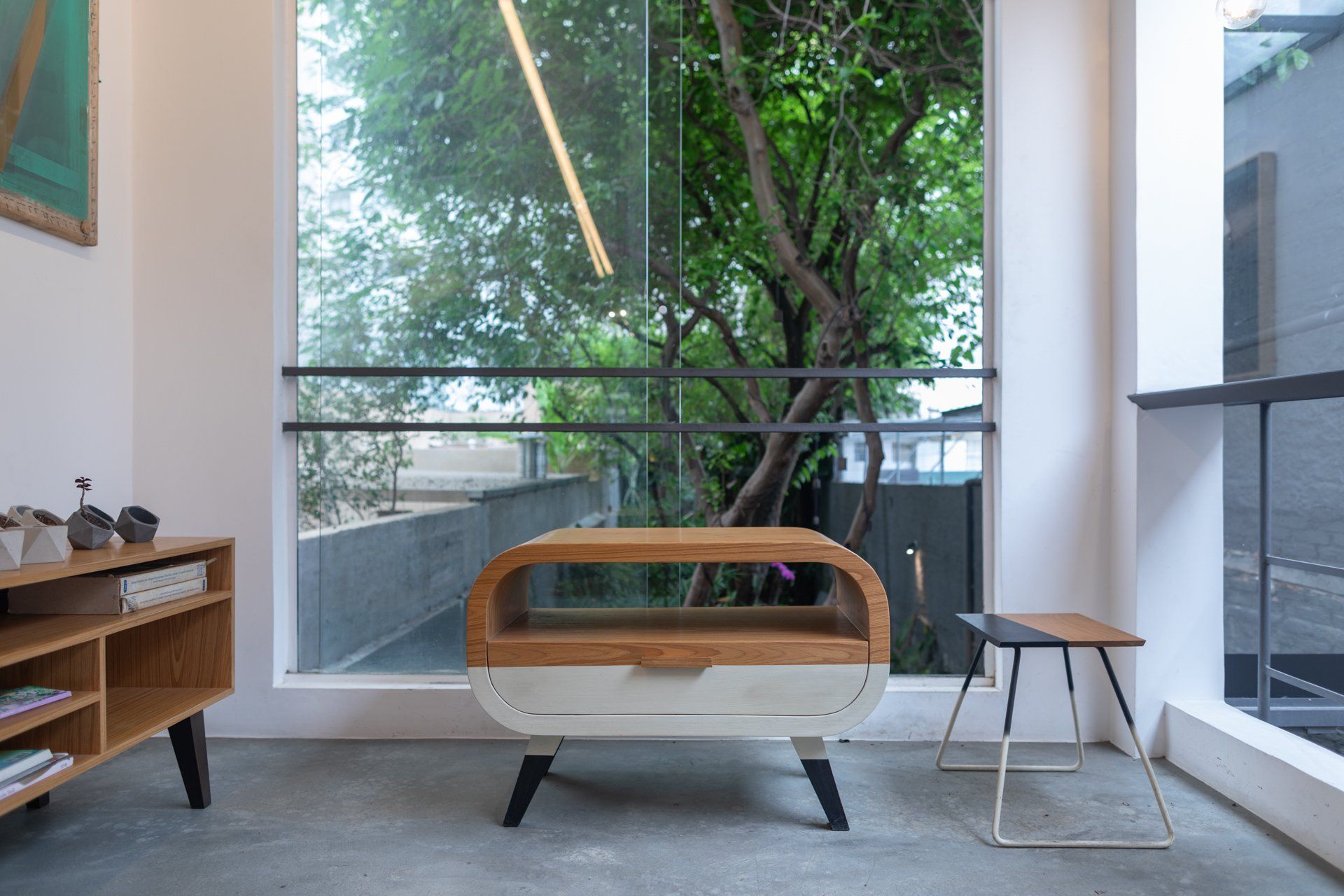 Uma sala com mesa e cadeira em frente a uma janela.