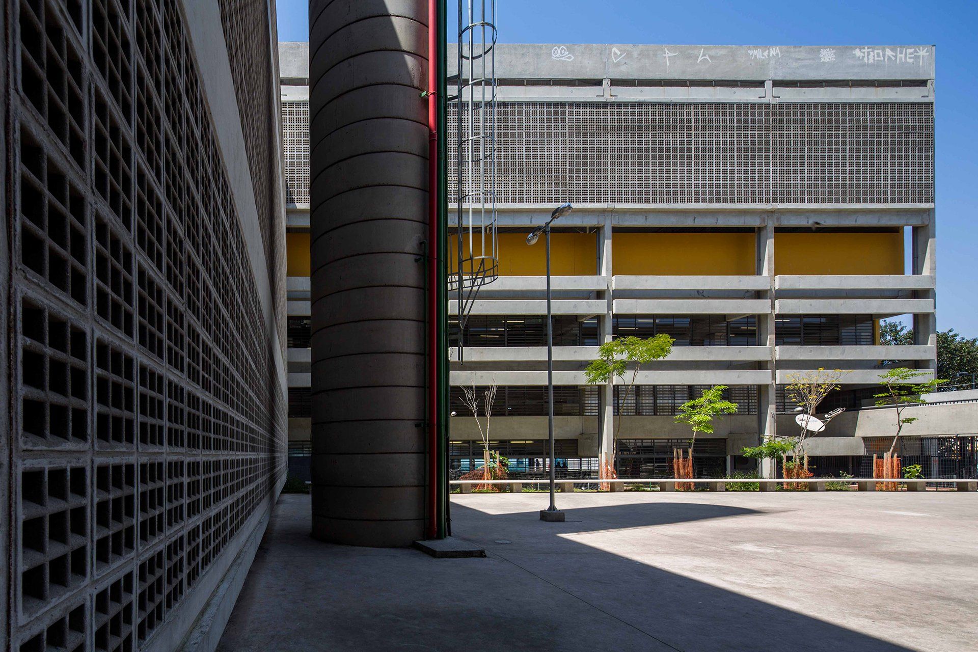 Um grande edifício com muitas janelas é cercado por uma parede de tijolos.