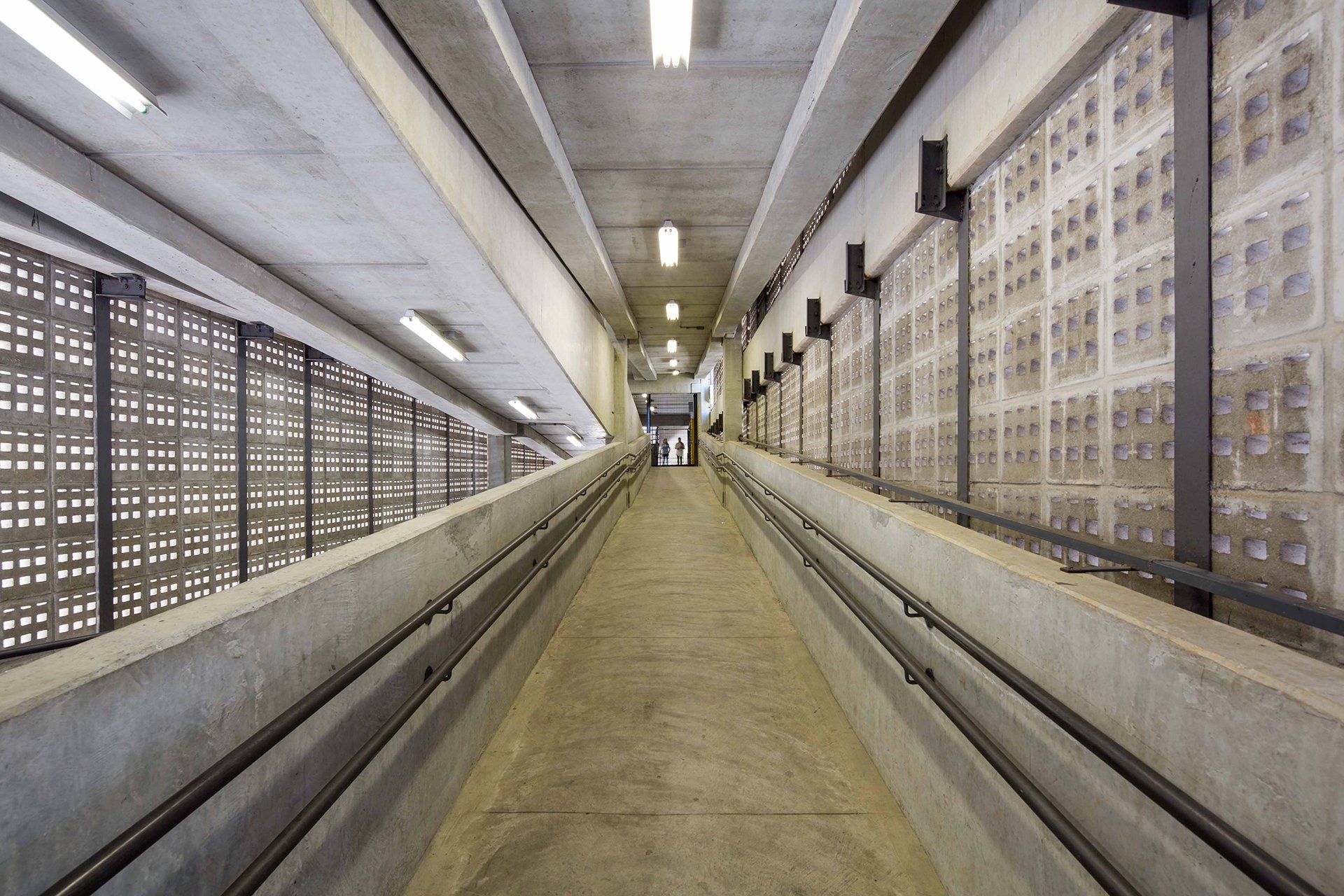 Um longo corredor com uma escada subindo até o topo