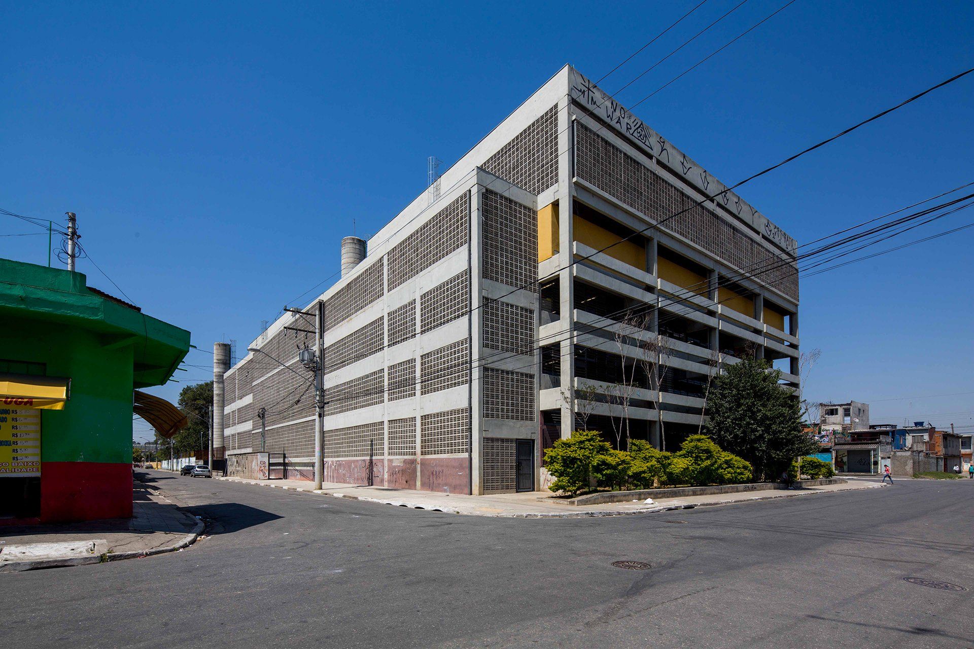 Um grande edifício com um edifício verde na frente