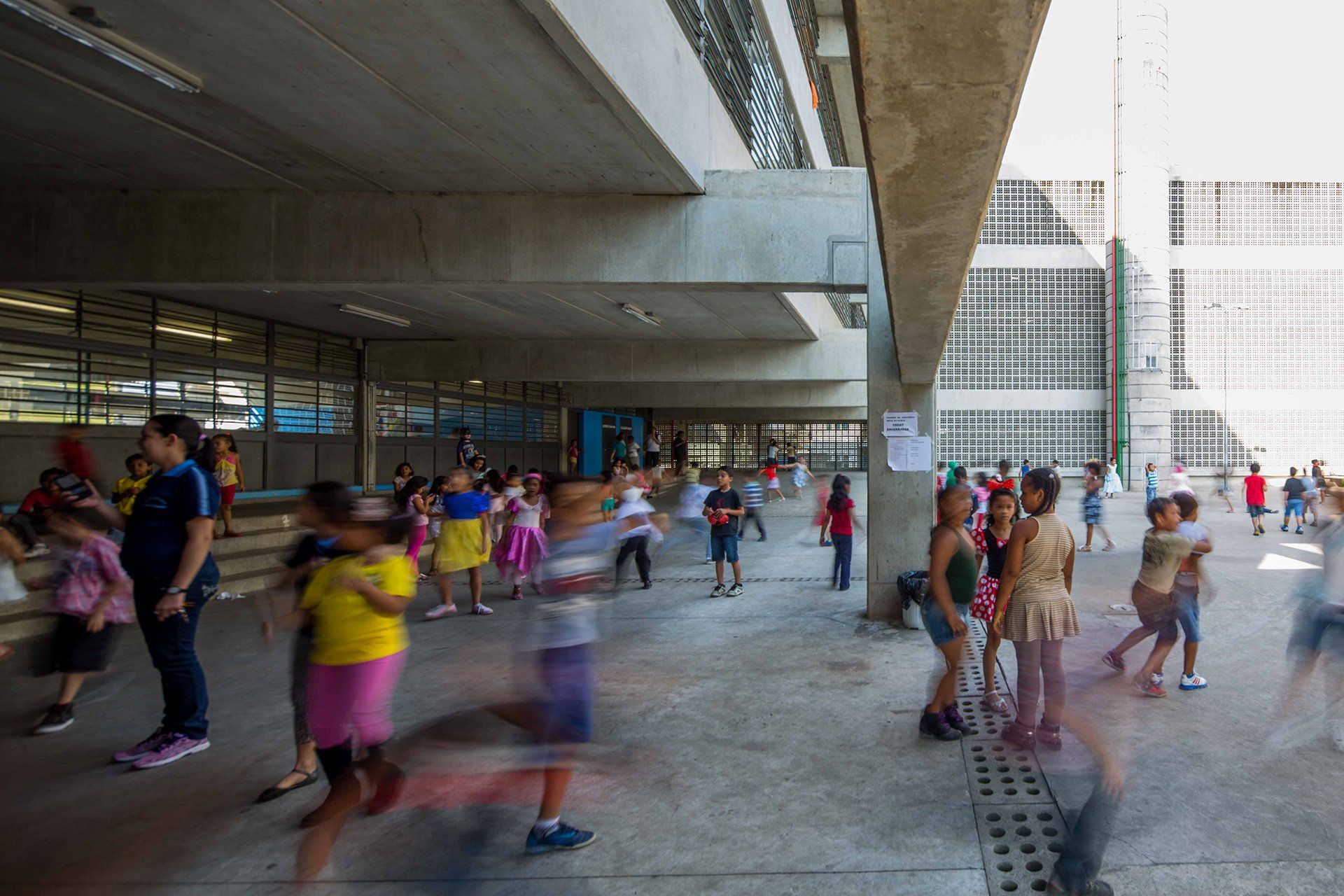 Um grupo de crianças está brincando do lado de fora de um prédio.