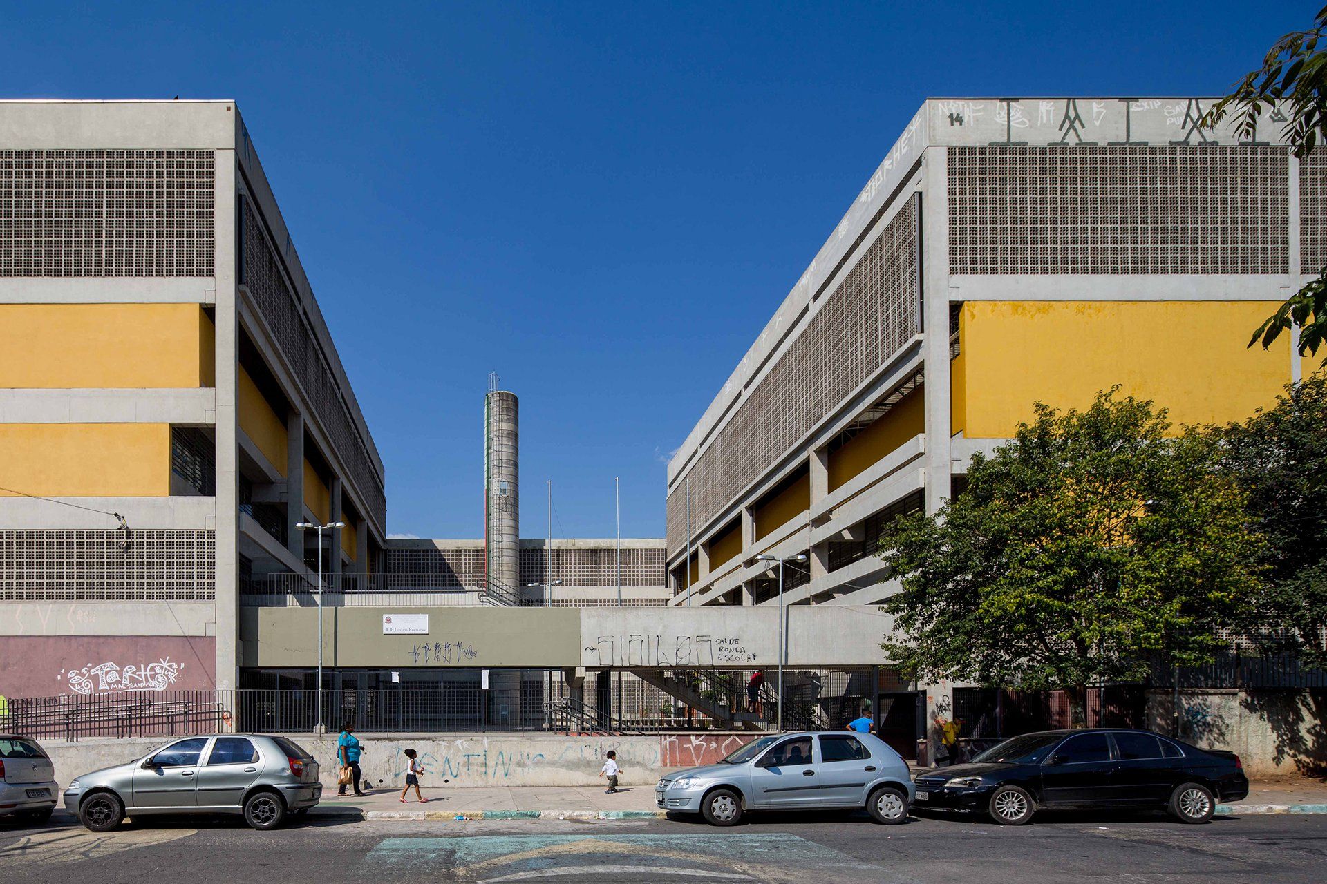 Um grande edifício com carros estacionados em frente