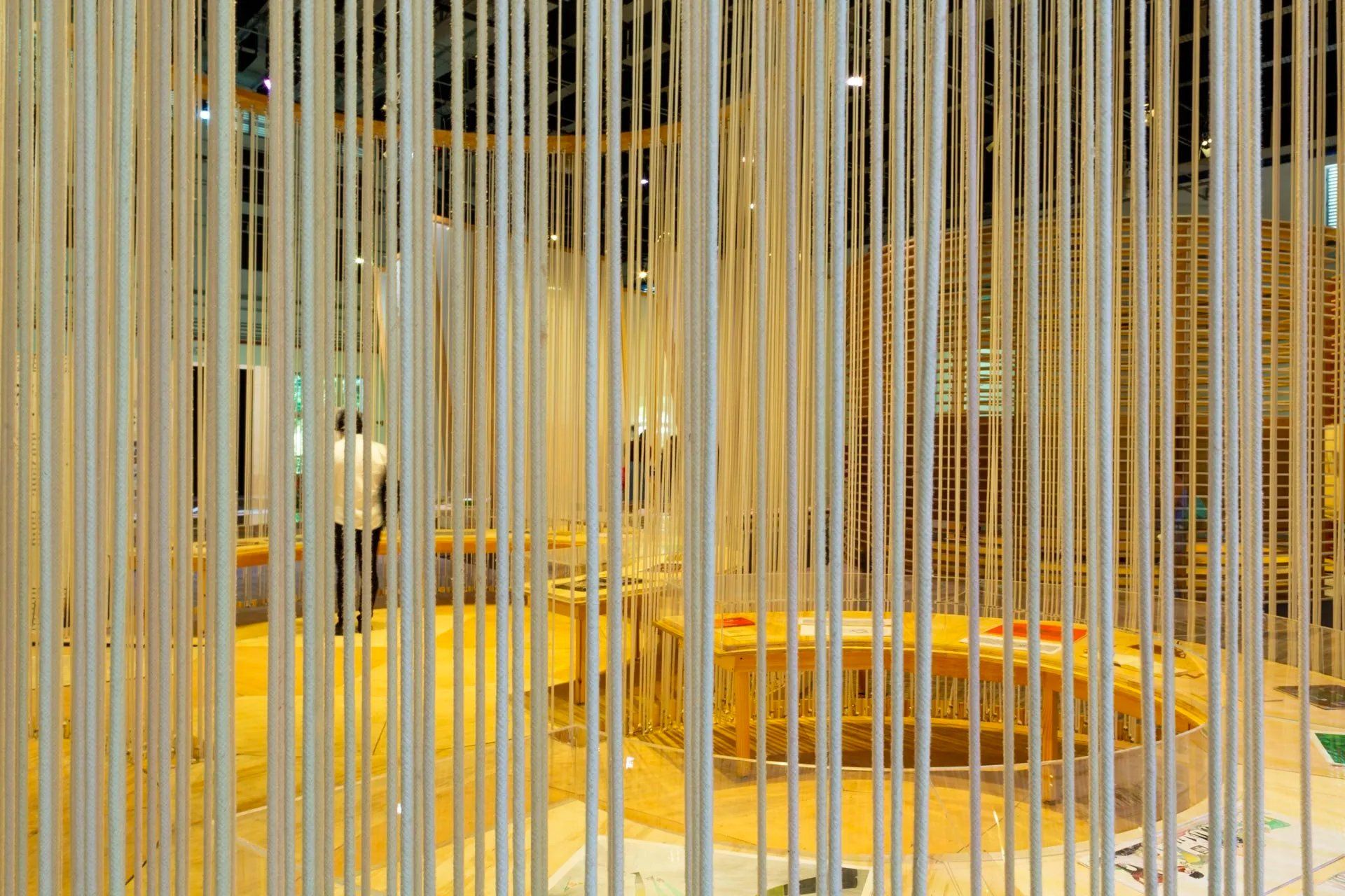 Uma sala com uma fileira de gravetos brancos pendurados no teto.