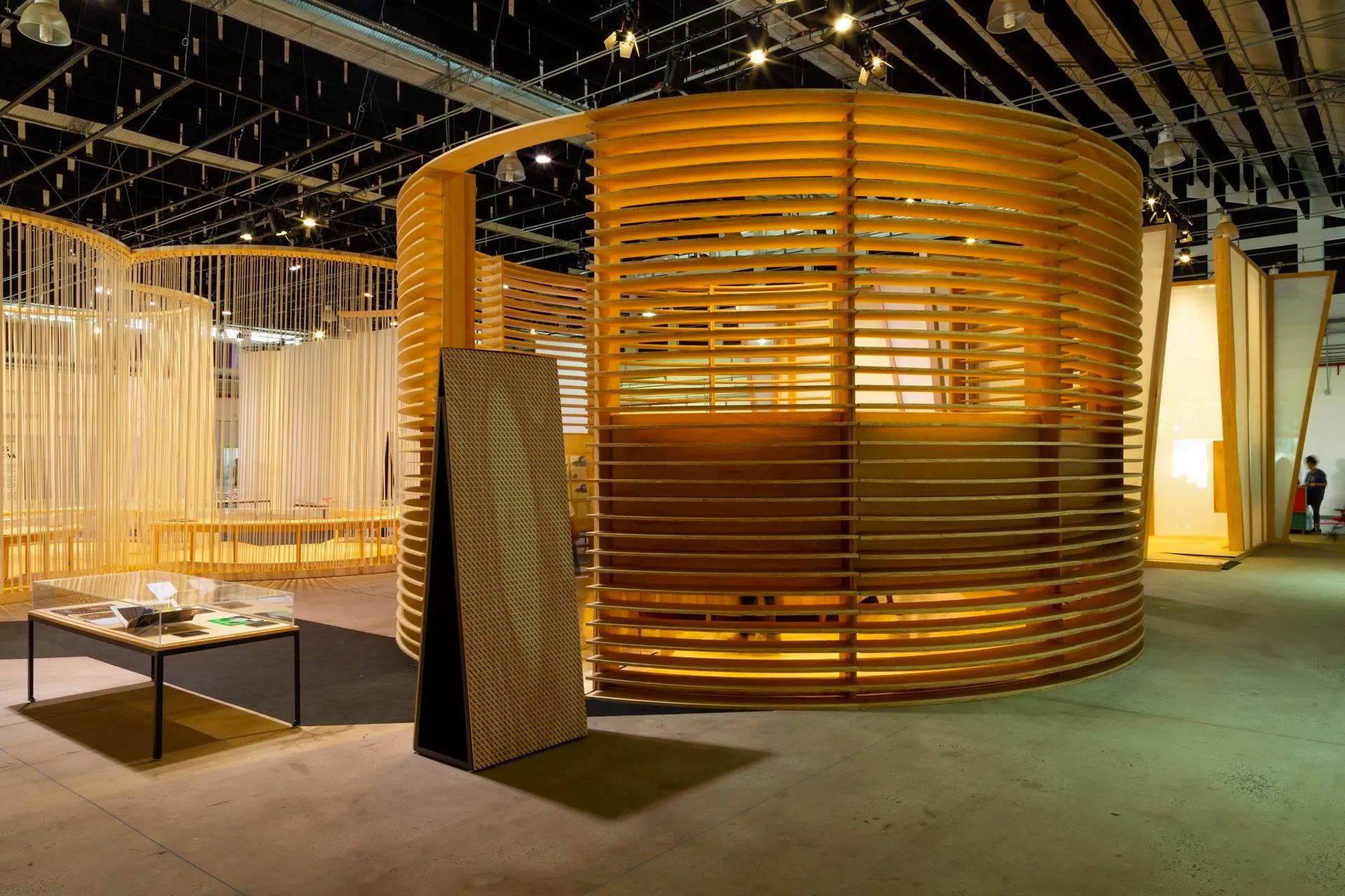 Uma grande sala com uma estrutura circular de madeira no meio.