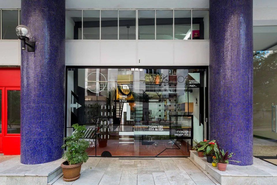 Um prédio com colunas roxas e uma porta de vidro