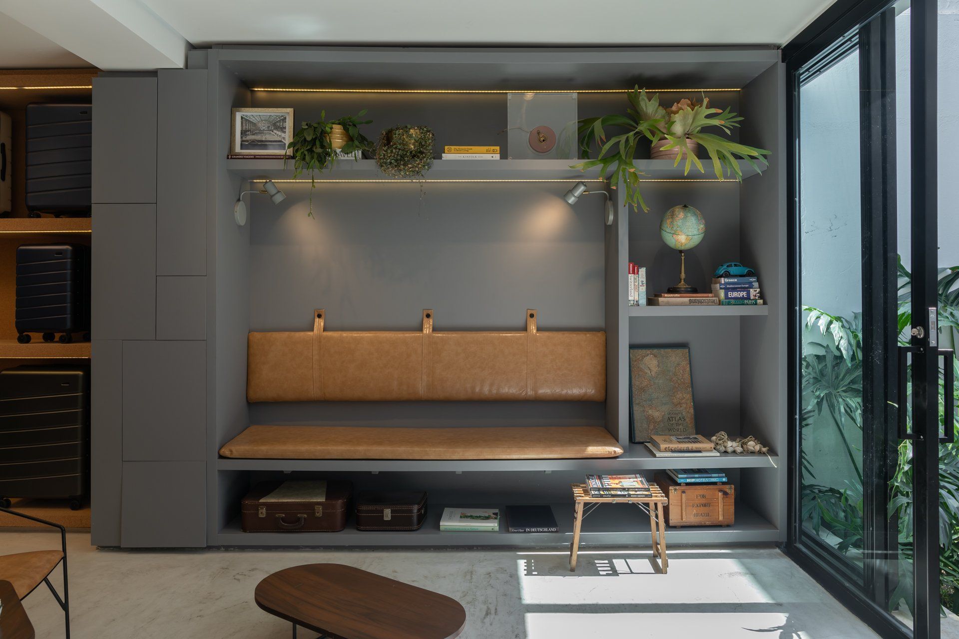 Uma sala de estar com sofá, estantes e mesa.