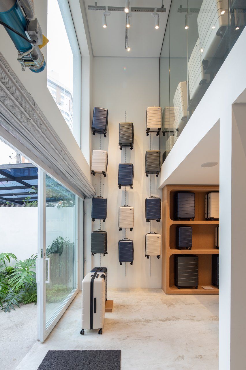 Um quarto com muita bagagem pendurada na parede