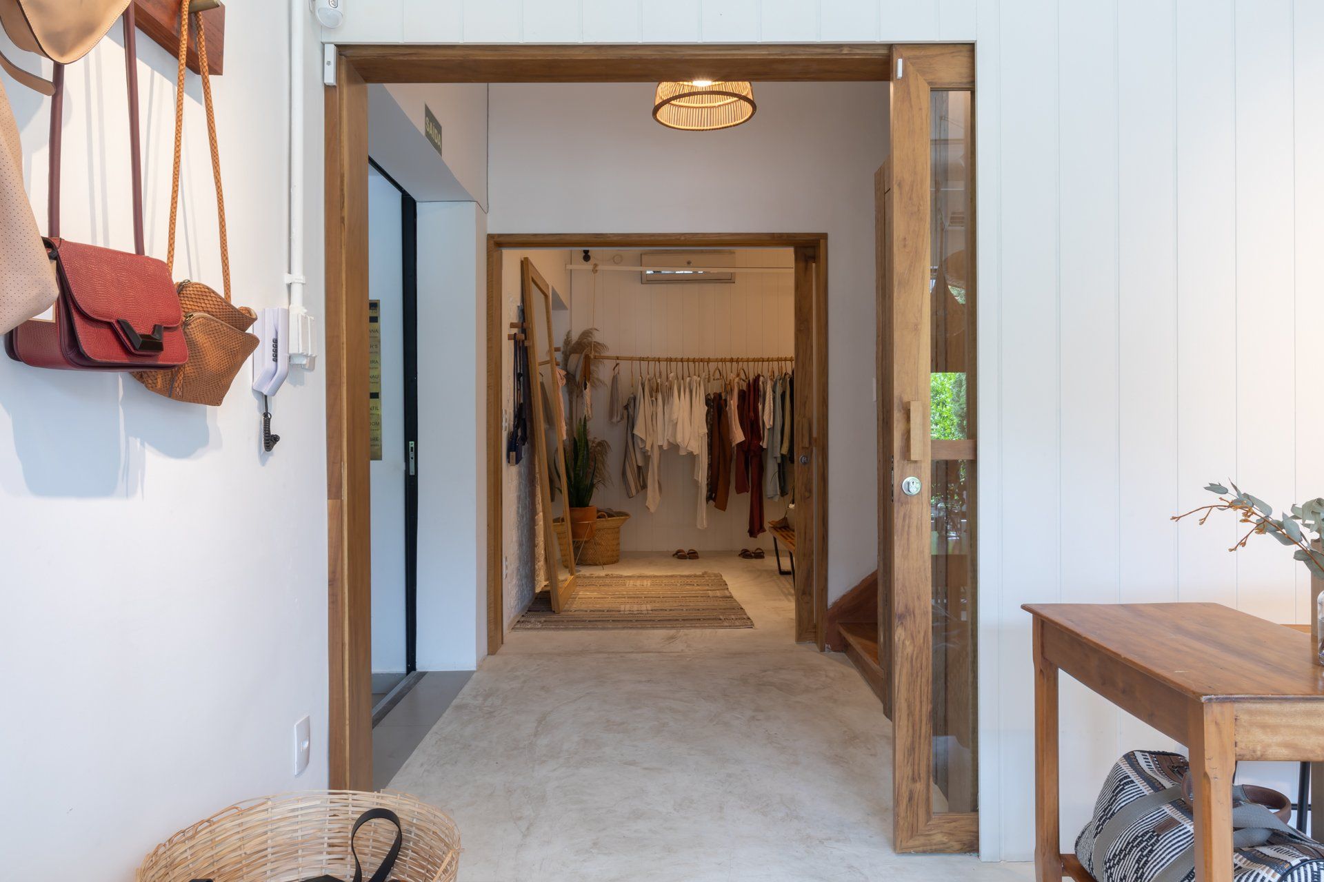 Um corredor com uma porta de madeira que leva a uma loja de roupas.
