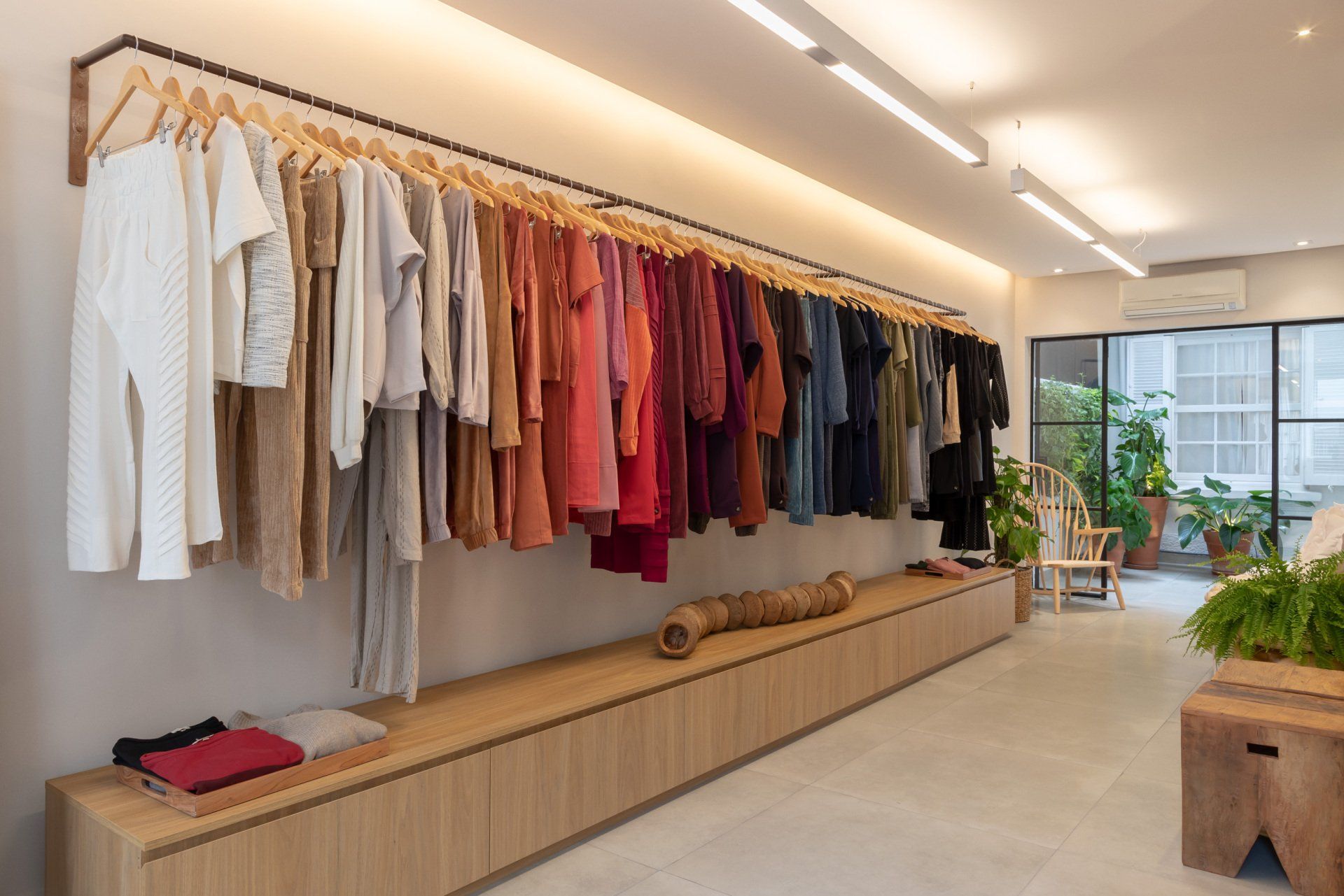 Uma fileira de roupas penduradas em um cabide de uma loja.