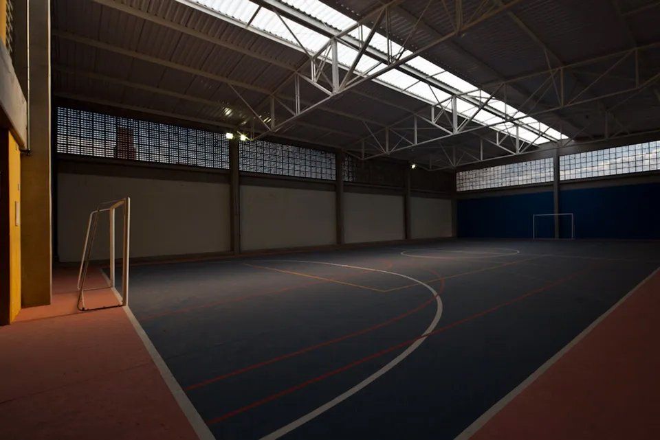 Uma quadra de basquete coberta vazia com um gol no meio