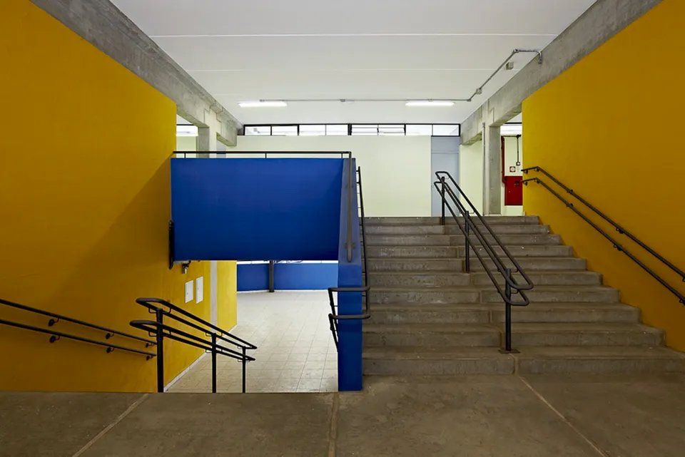Uma escada em um prédio com paredes amarelas e paredes azuis