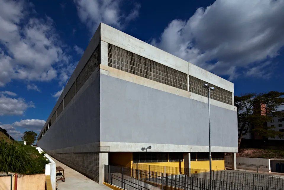 Um grande edifício com muitas janelas e uma cerca ao redor