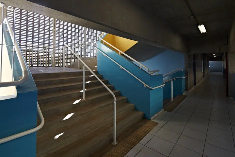 Um corredor com escadas e uma parede azul