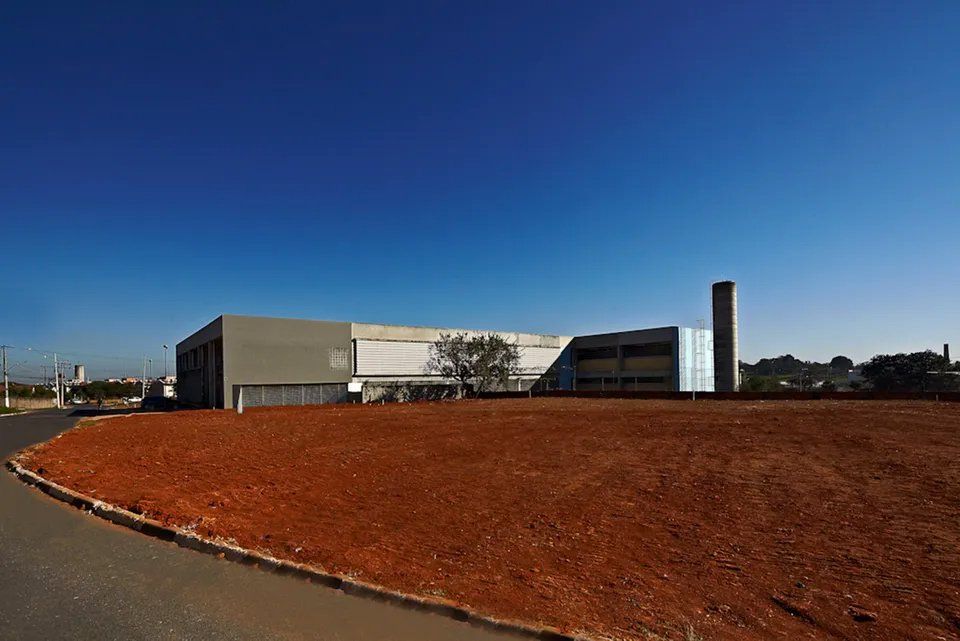 Um grande edifício está situado no meio de um campo de terra.