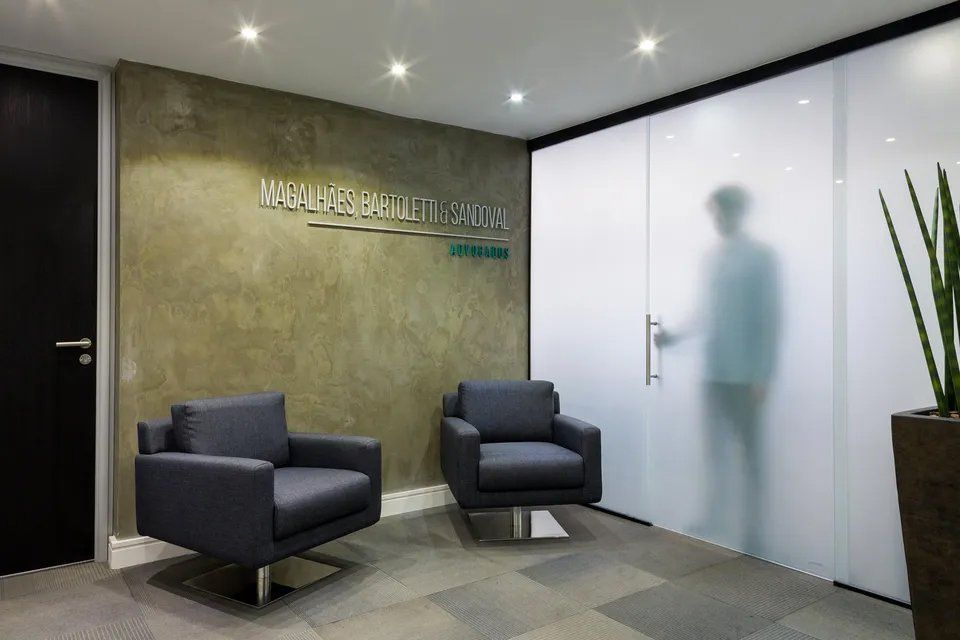 Uma sala de espera com duas cadeiras e uma porta de vidro