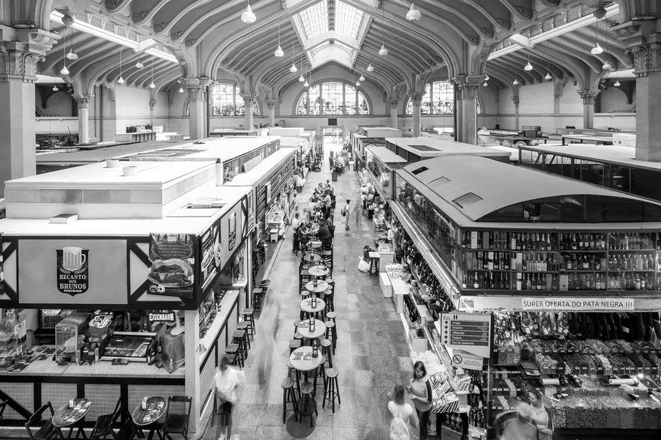 Uma foto em preto e branco de um mercado cheio de gente.