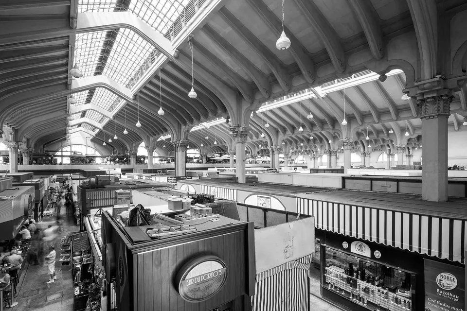 Uma foto em preto e branco de um grande edifício com muitas lojas.