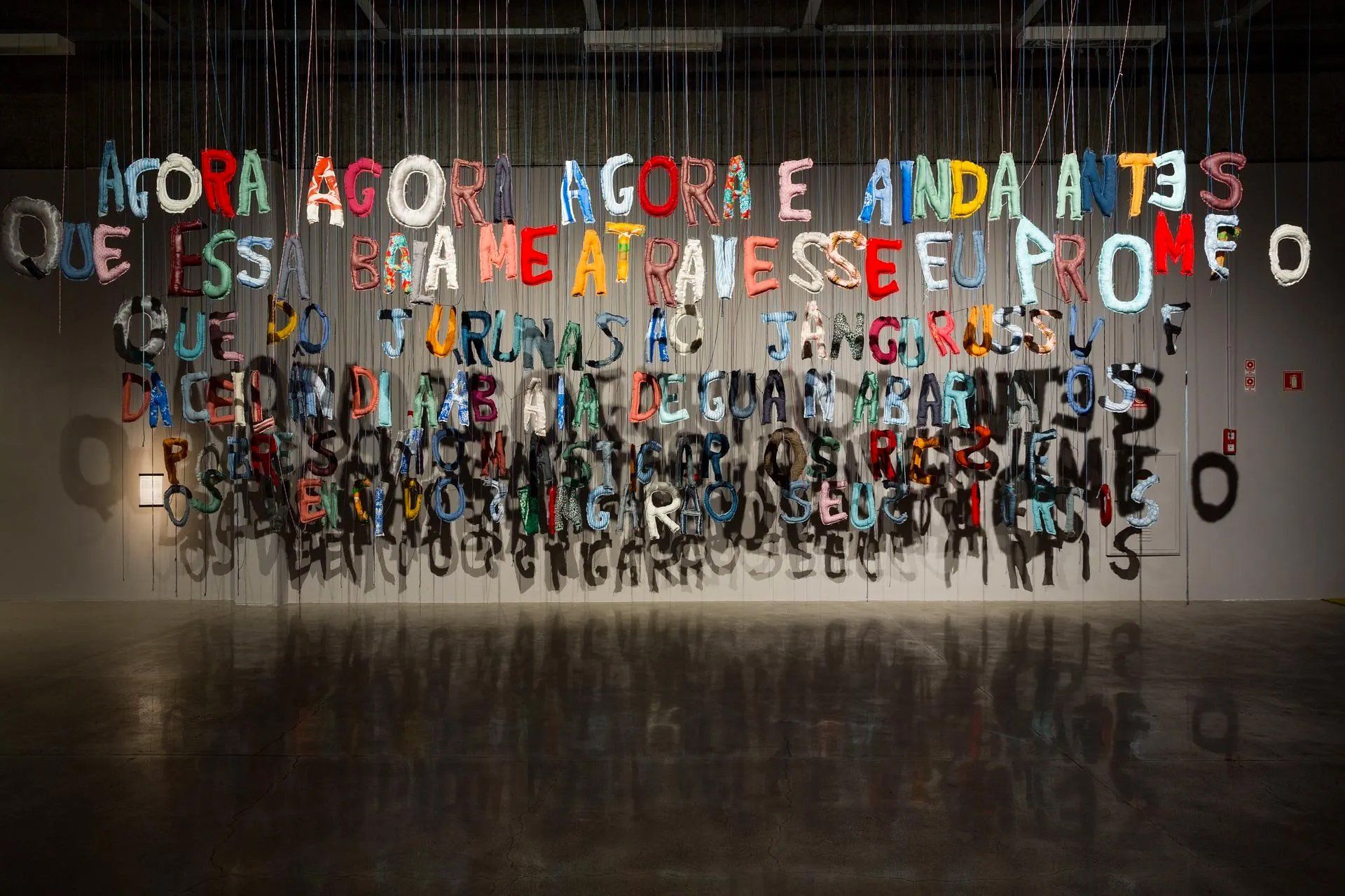 Uma parede com muitas letras penduradas no teto.