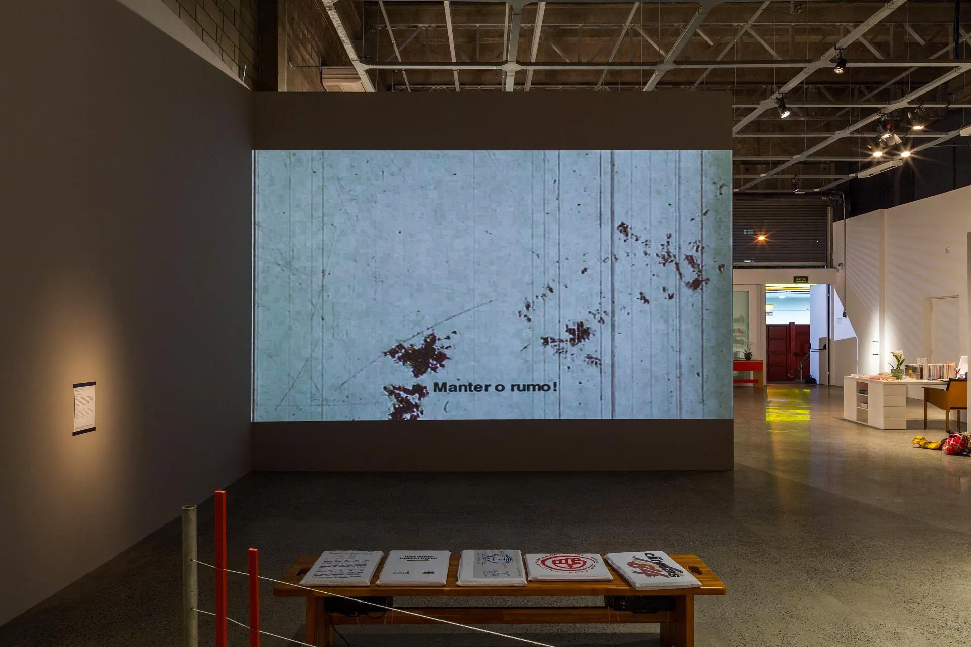 Uma grande tela em uma sala com uma mesa na frente dela.