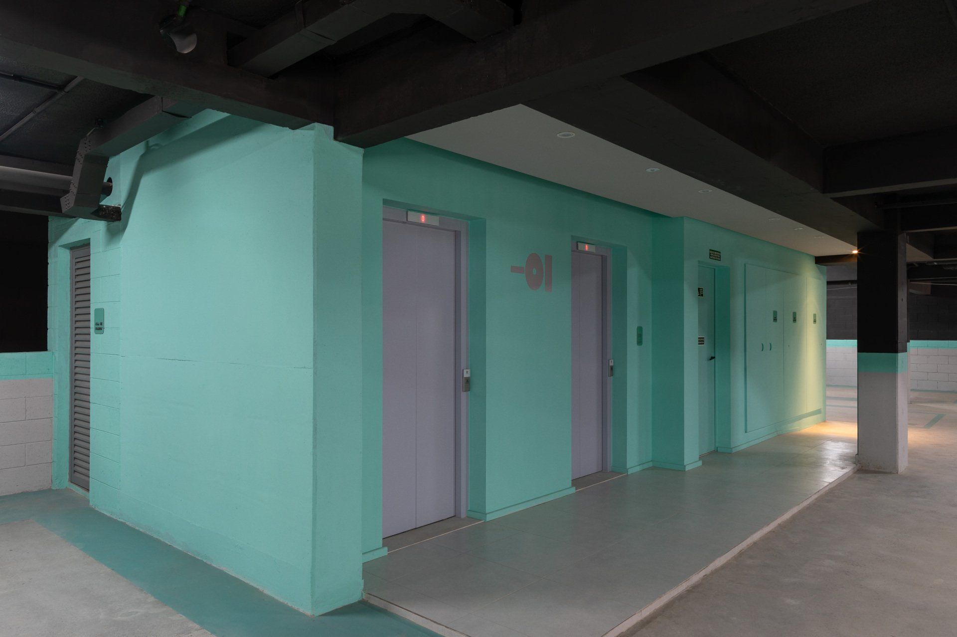 Um corredor com paredes verdes e portas roxas em um prédio.