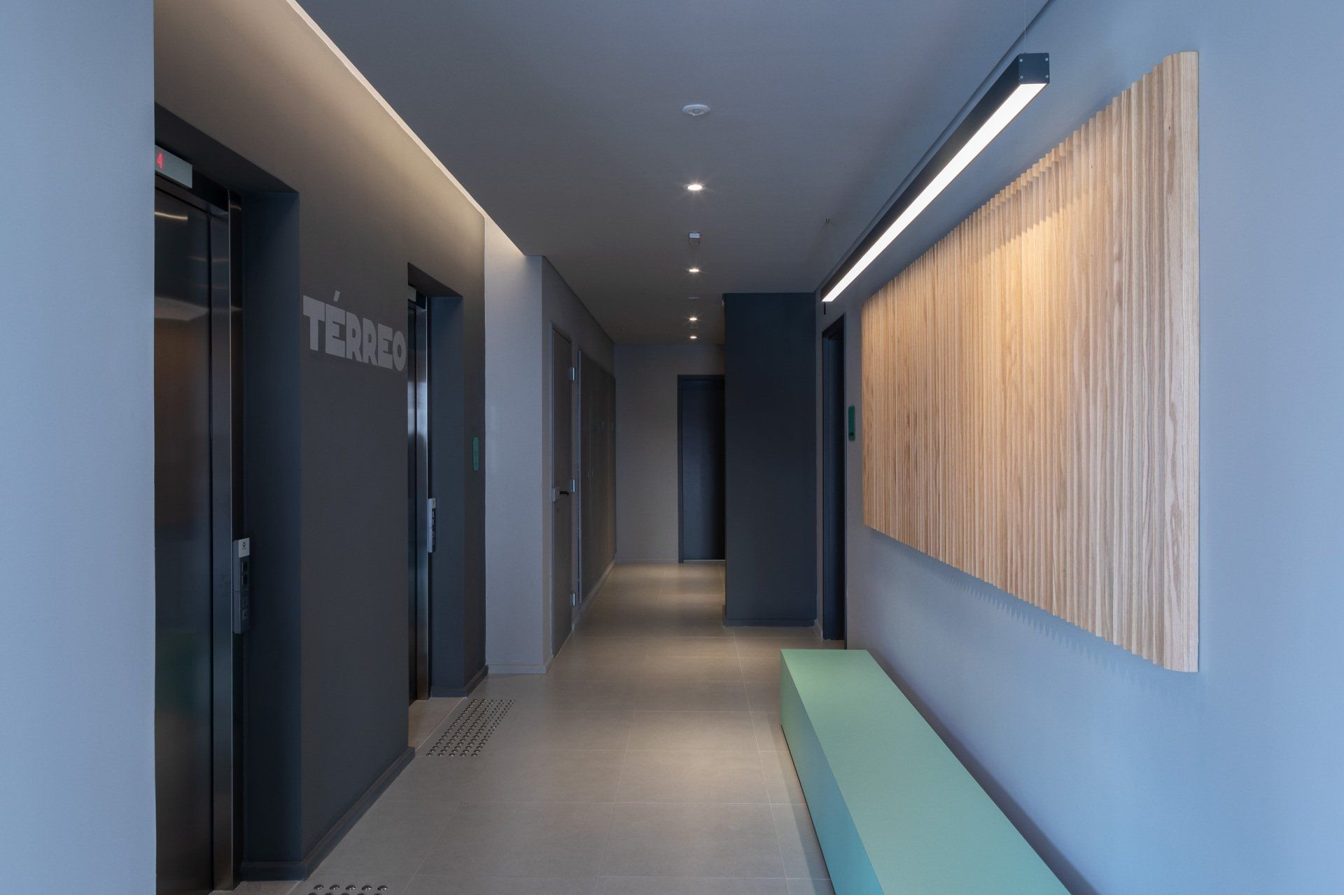 Um corredor com um banco e uma placa que diz tdms