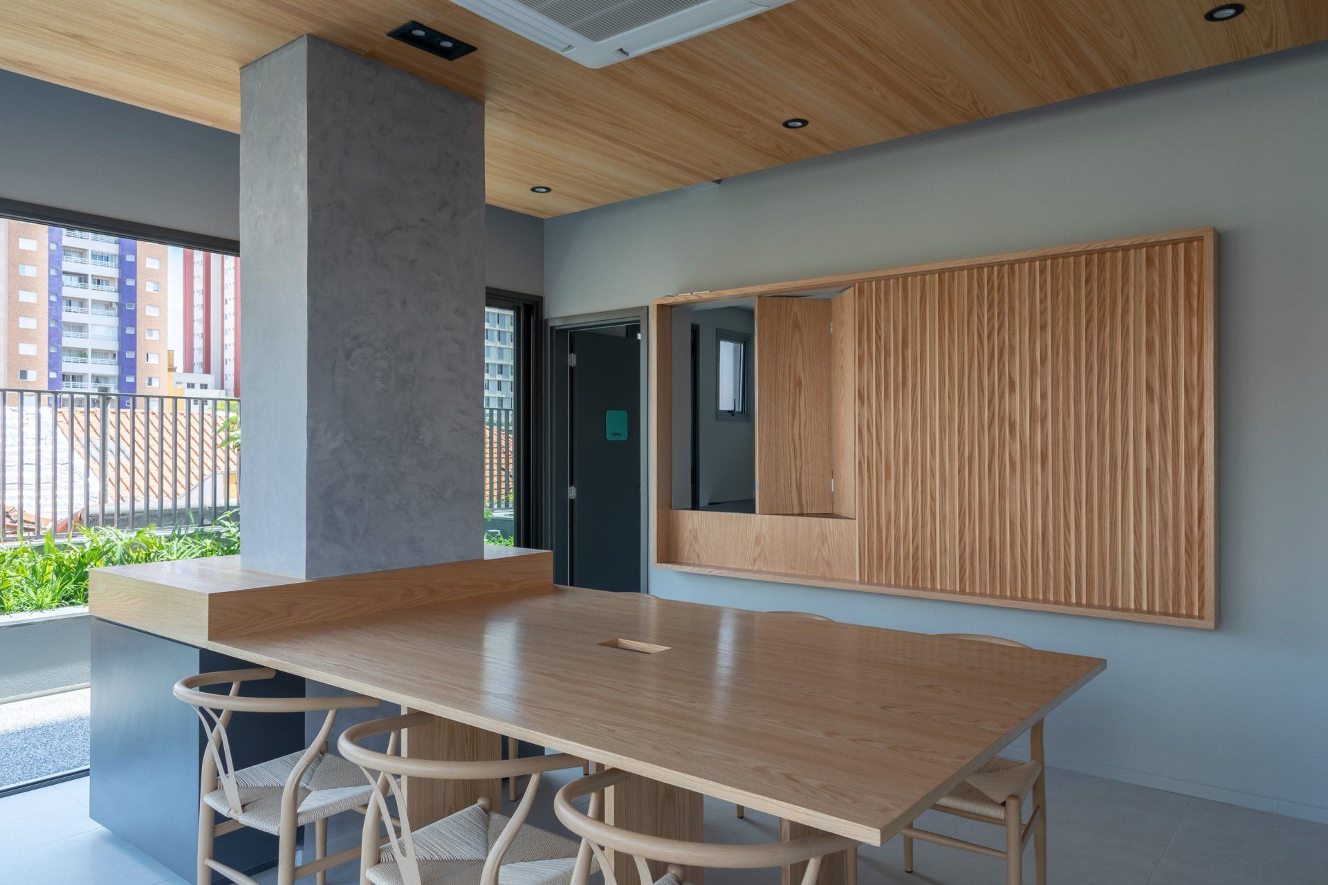 Há uma grande mesa e cadeiras de madeira na sala.