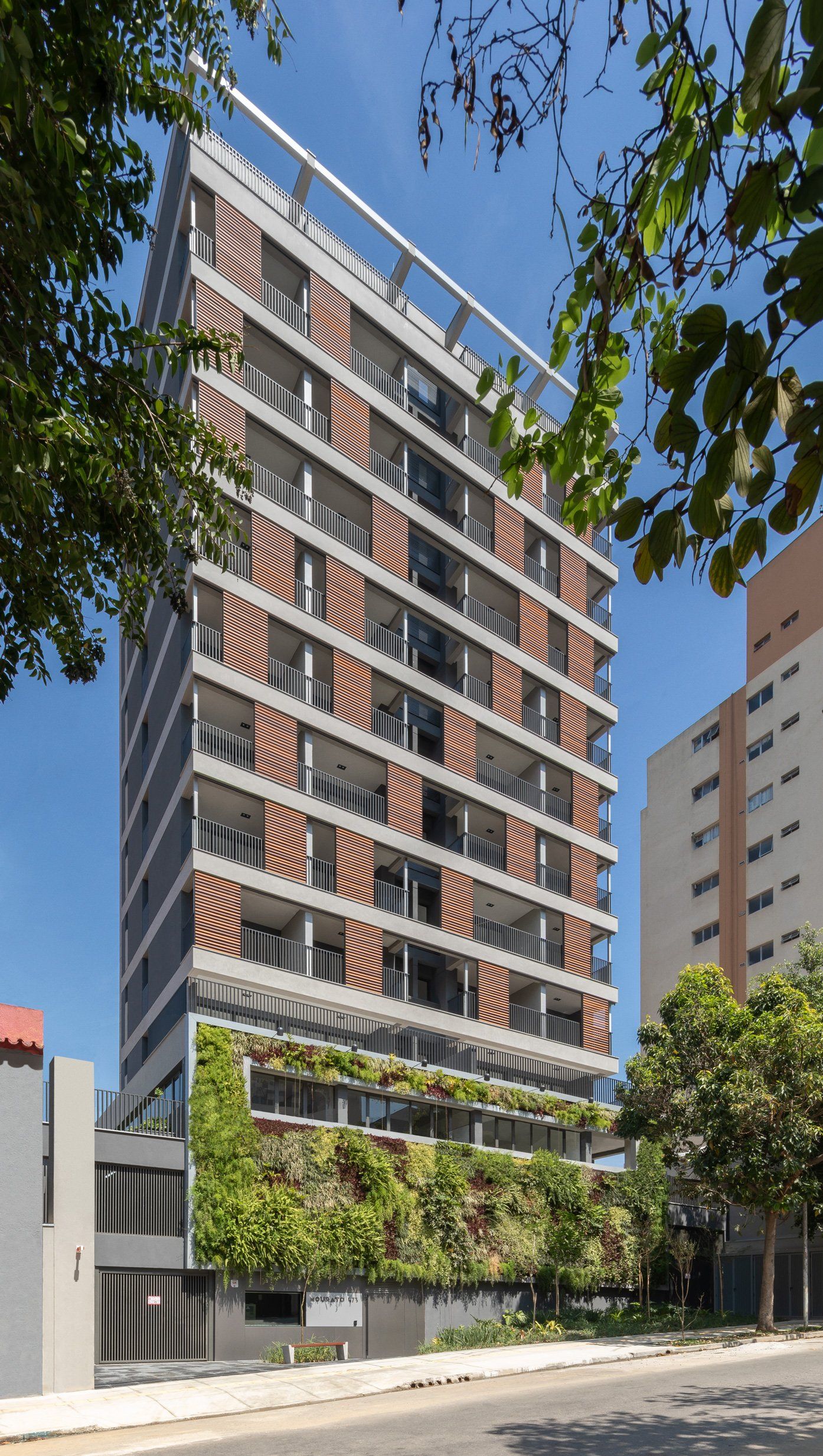 Um prédio alto com muitas janelas é cercado por árvores.