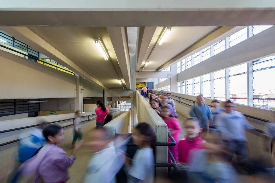 Uma imagem borrada de um grupo de pessoas andando por um corredor.