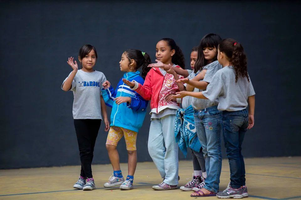 Um grupo de meninas está lado a lado em uma quadra.