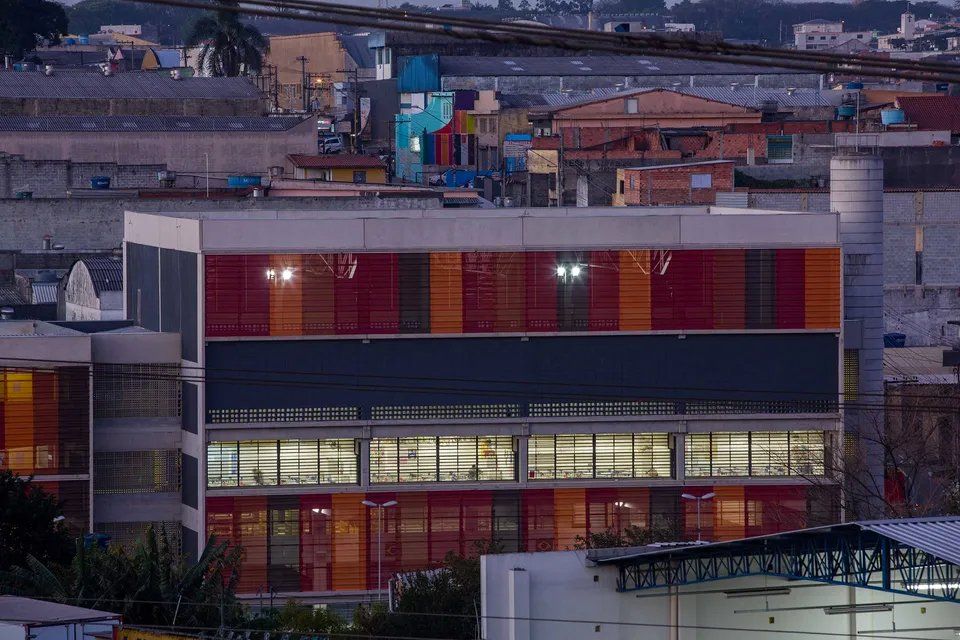 Um grande edifício com muitas janelas fica no meio de uma cidade.