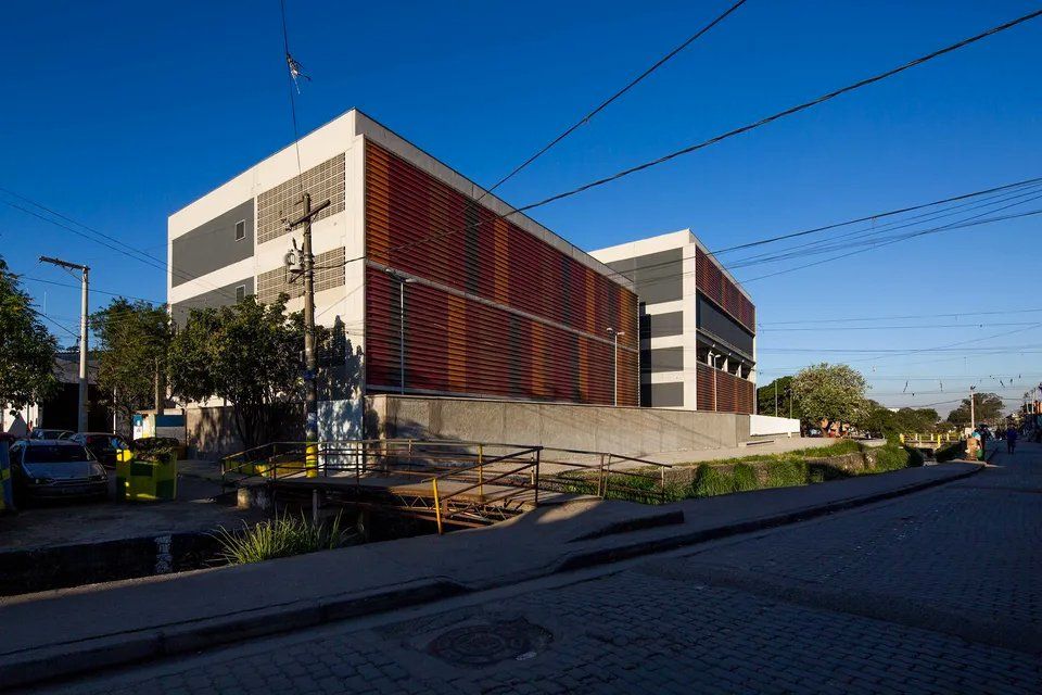 Um grande edifício está situado na beira de uma estrada.