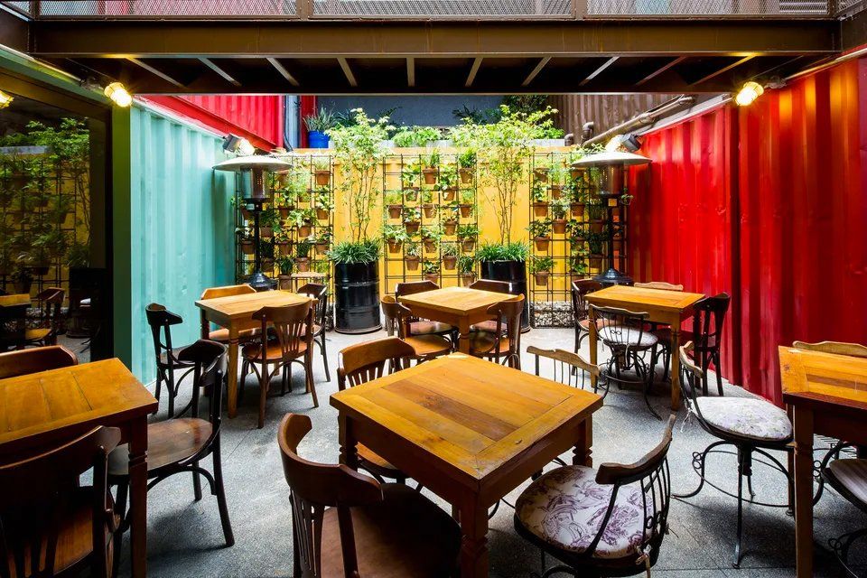 Um restaurante repleto de mesas e cadeiras de madeira.