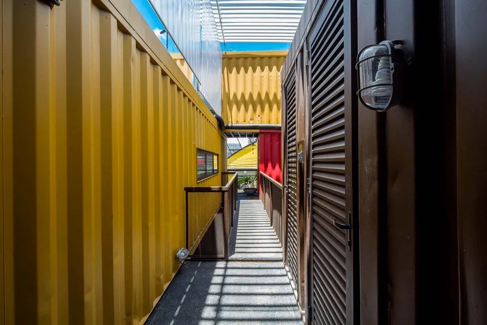 Um corredor entre dois contêineres em um prédio.