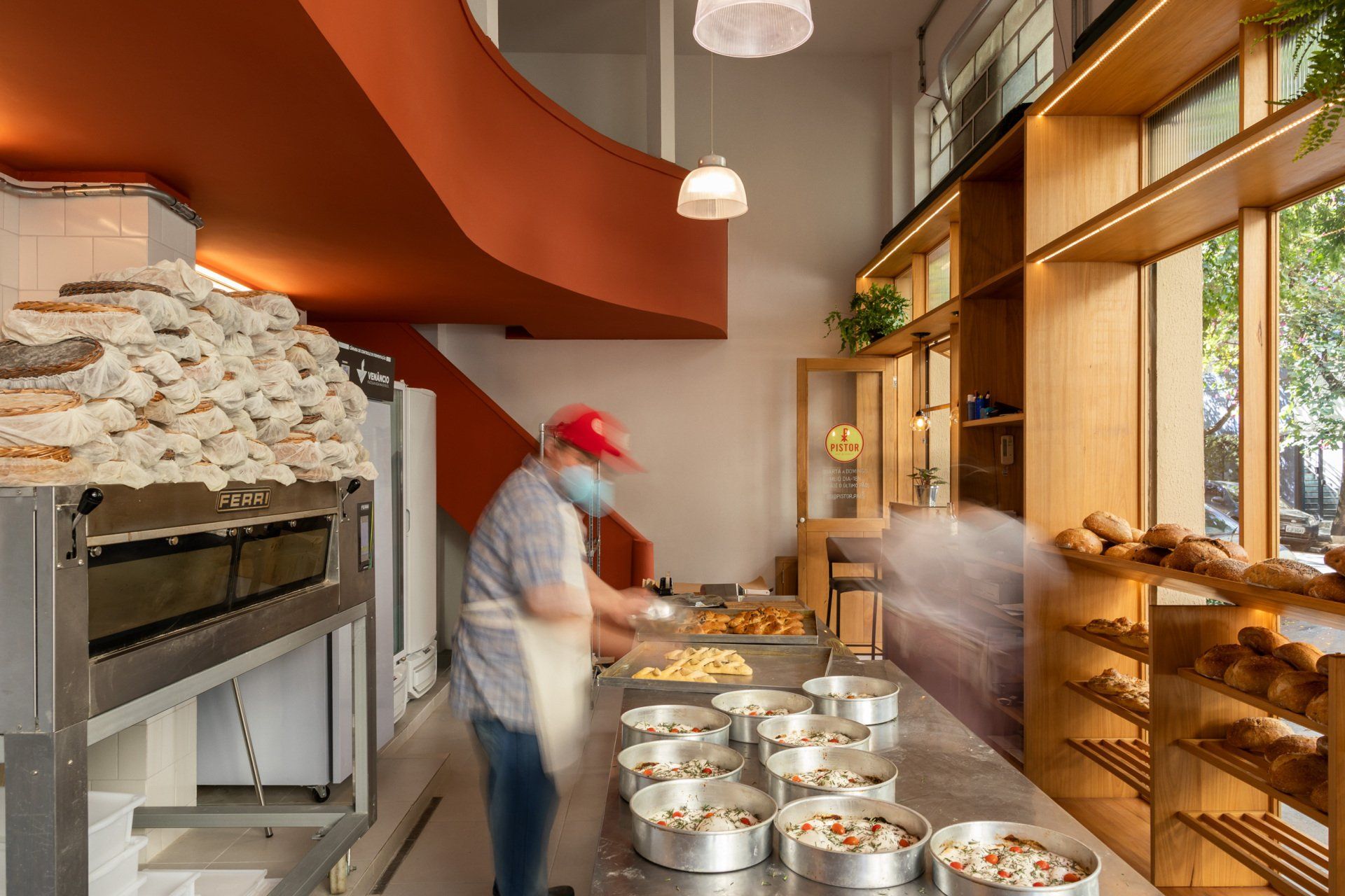Um homem está em uma padaria preparando comida.