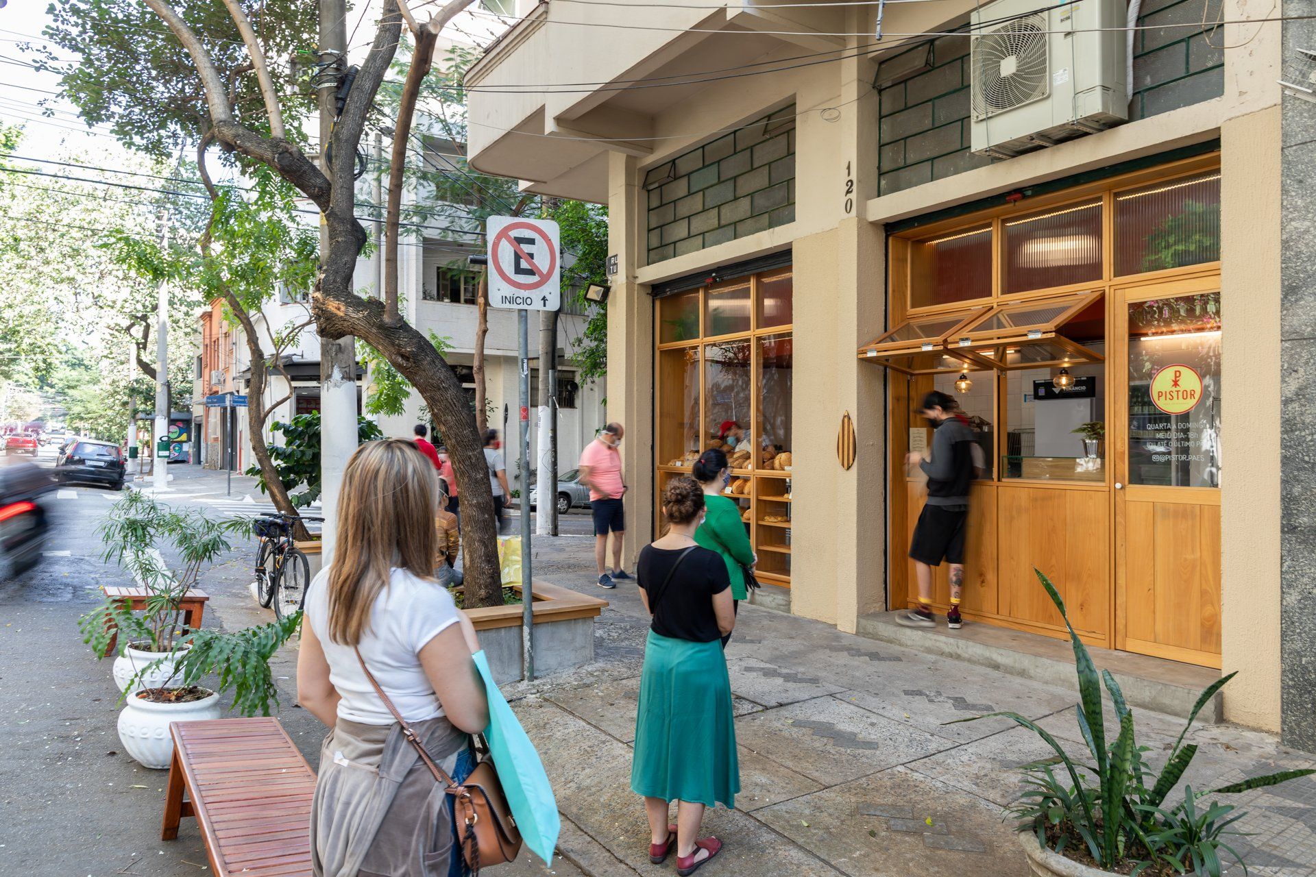 Um grupo de pessoas está do lado de fora de um restaurante.