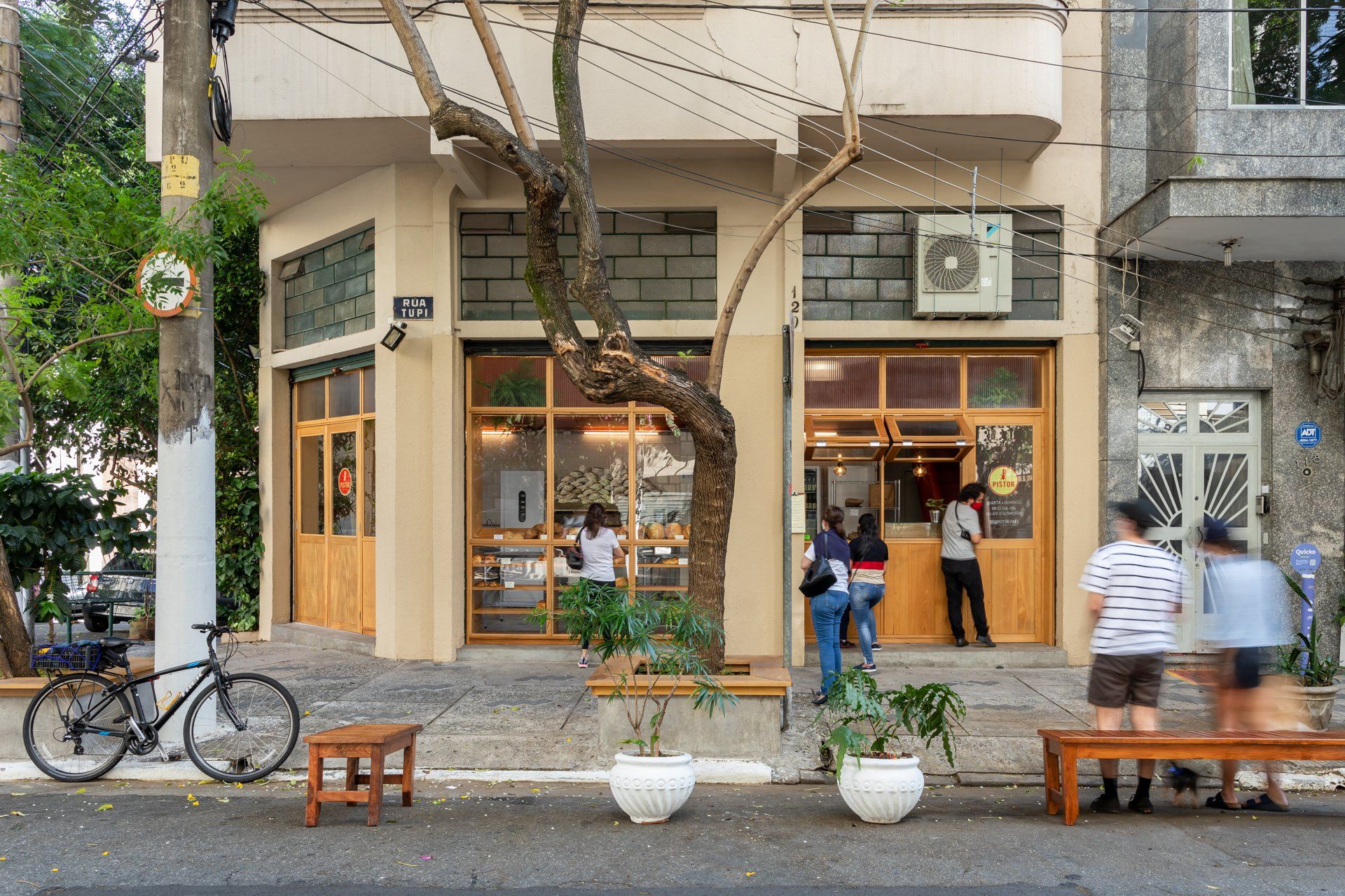 Um grupo de pessoas está do lado de fora de um prédio.