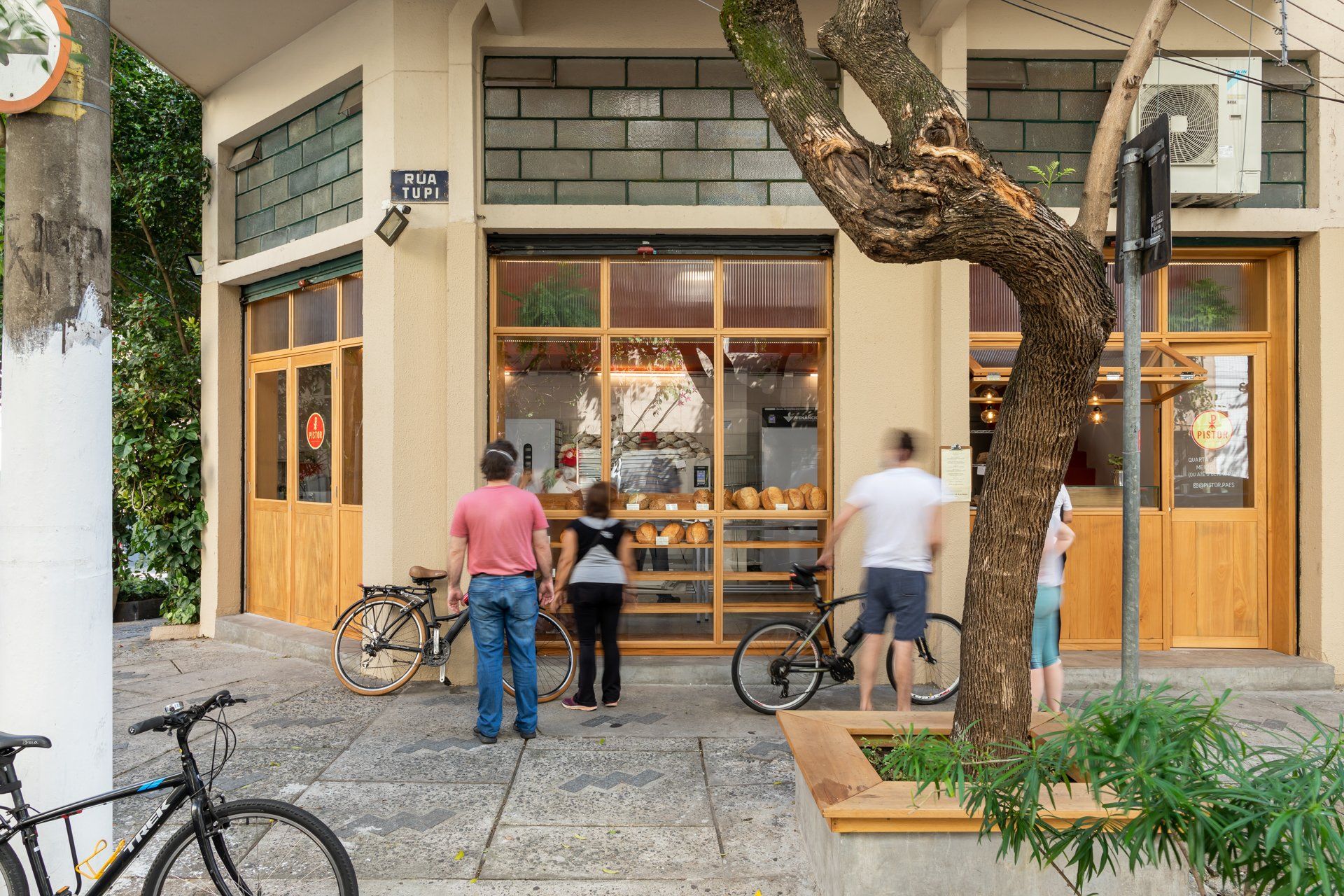 Um grupo de pessoas está do lado de fora de uma padaria.